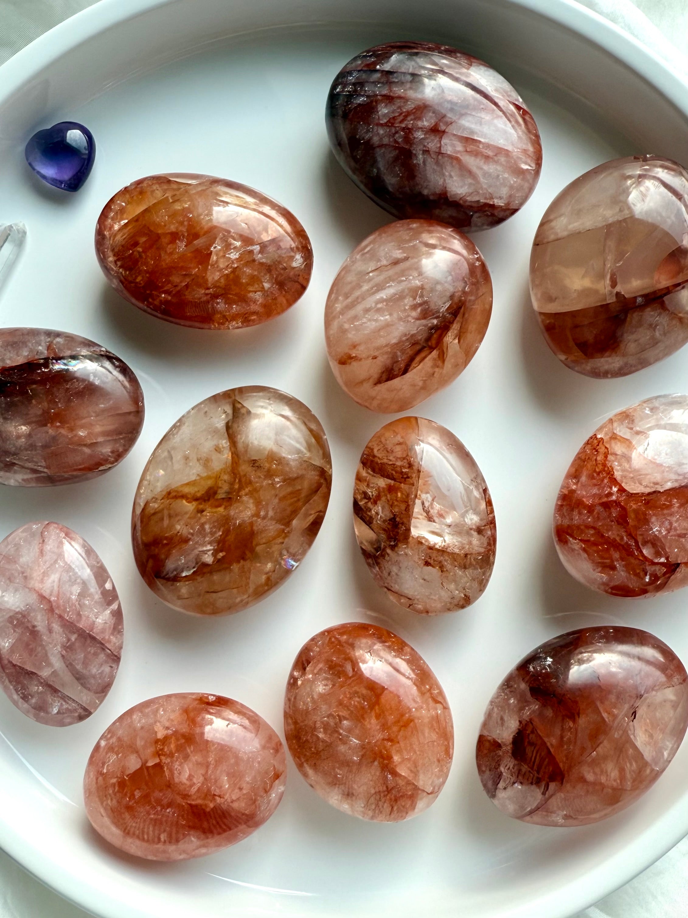 Collection of Fire Quartz palm stones with unique hematite patterns for courage, focus, and grounding