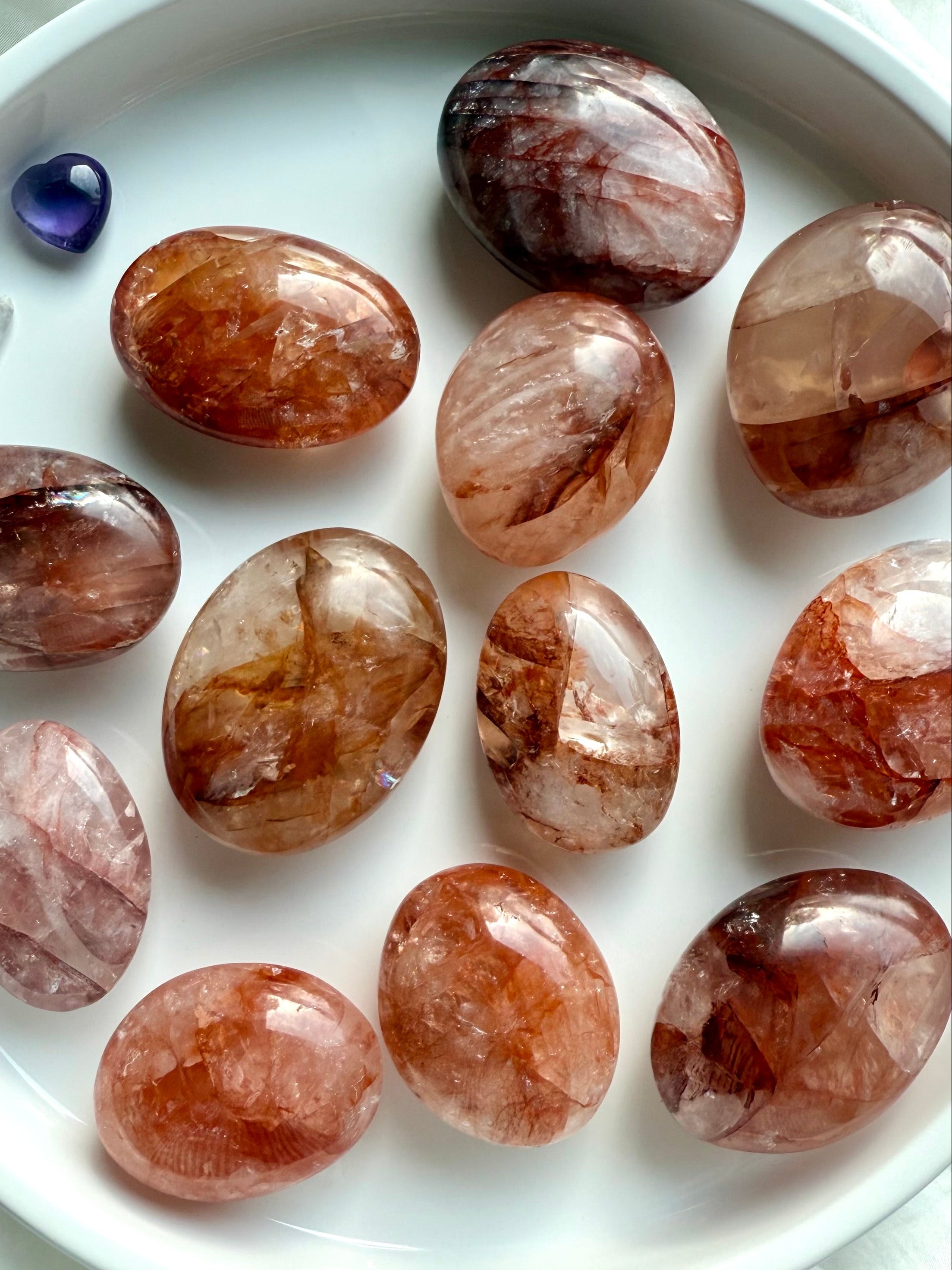 Collection of Fire Quartz palm stones with unique hematite patterns for courage, focus, and grounding