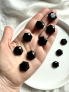 High-polish Black Obsidian hexagon with reflective surface shown on hand 