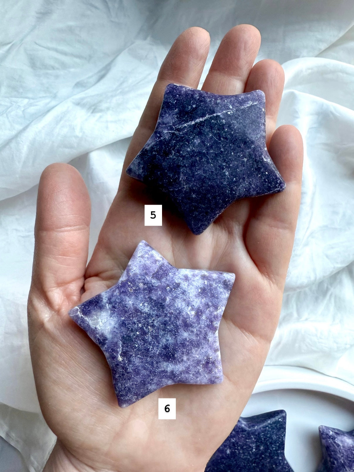 Back view of two numbered Lepidolite star carvings in deep purple with natural variations, smooth polished crystal for chakra balance.