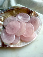 rose quartz worry stones grouped on a seashell for meditation, calming crystal collection