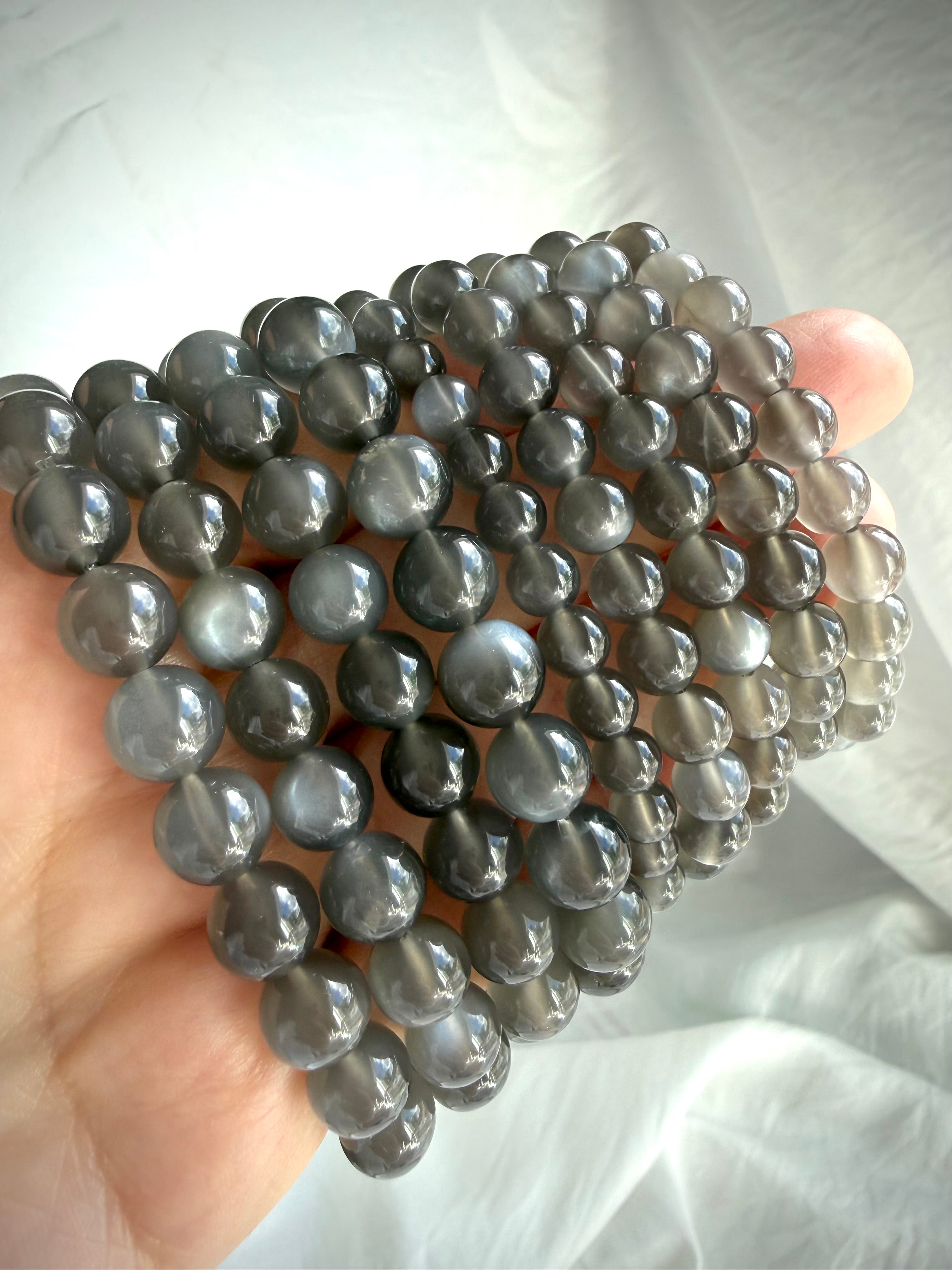 Black Moonstone bracelets in multiple bead sizes with moonlit shimmer, adularescence, and translucent charcoal gray tones
