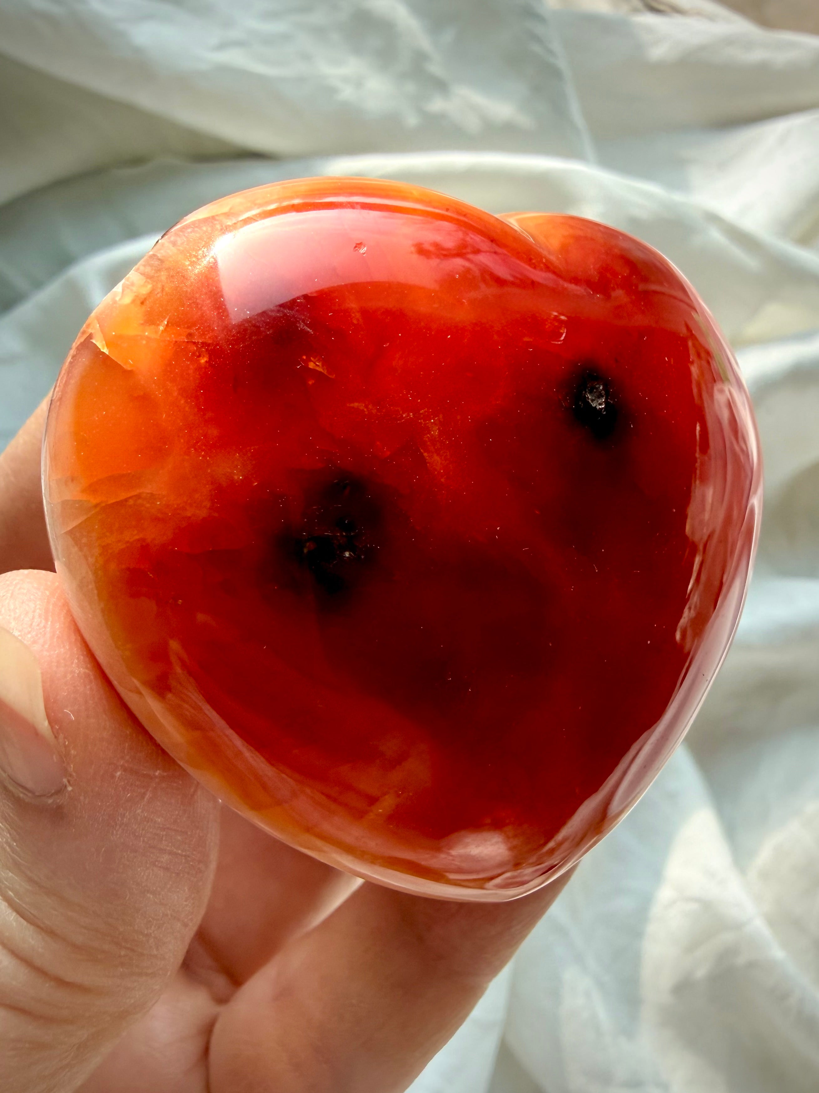 One of a kind Carnelian heart resting in palm, fiery sunset tones with subtle inclusions and high polish finish