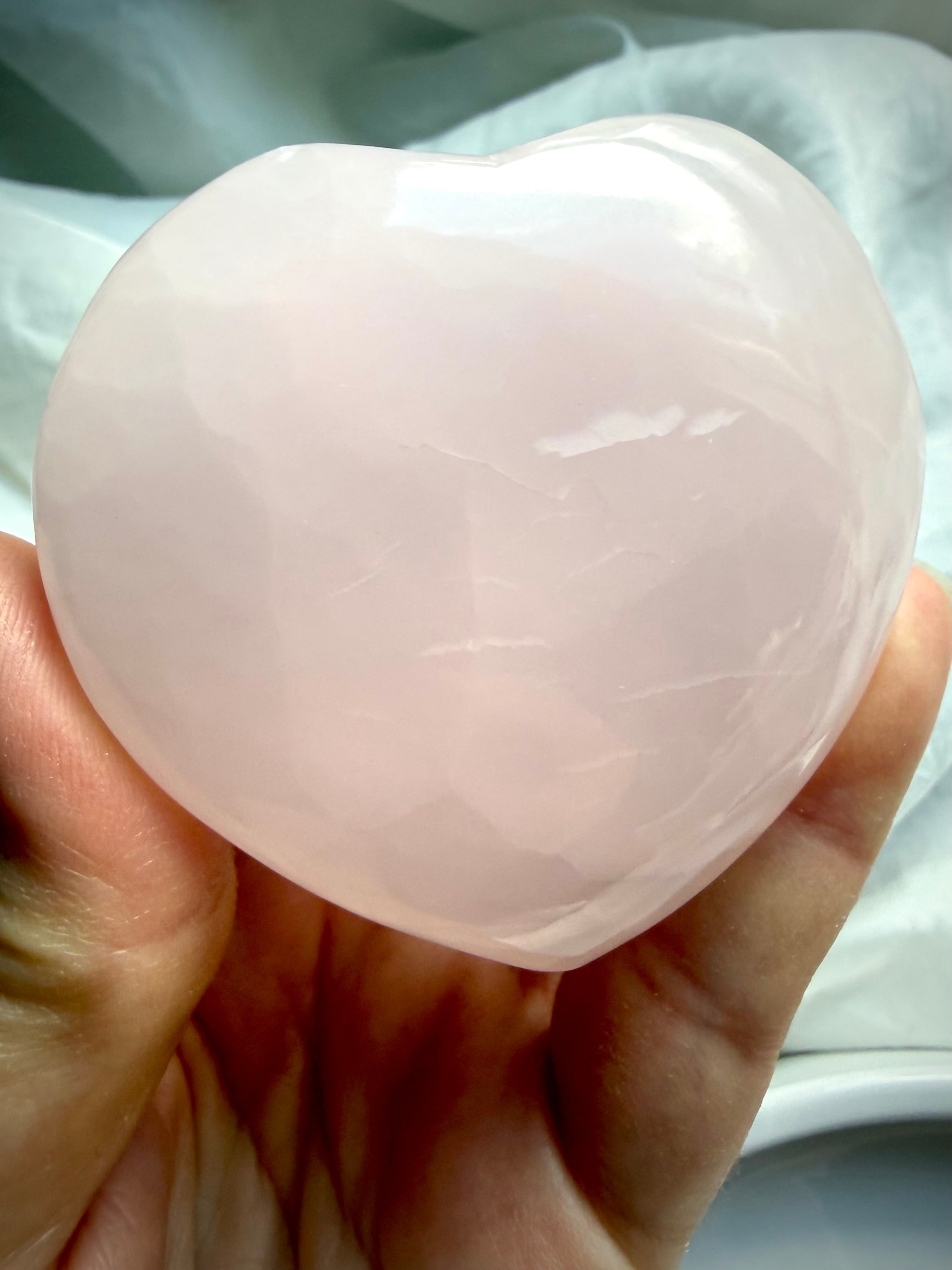 Heart Chakra crystal carving in natural Mangano Calcite with soothing blush pink glow and polished finish