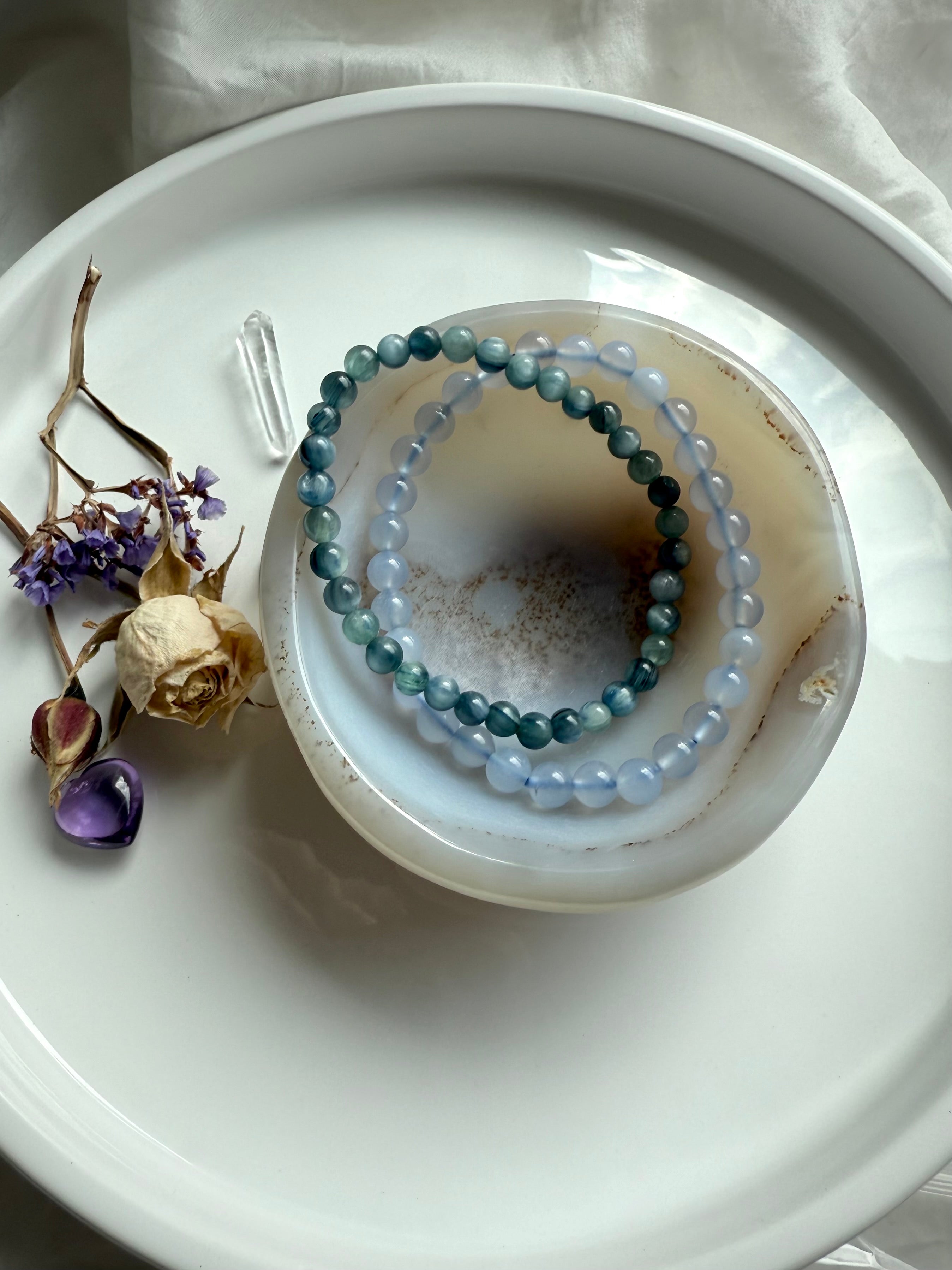 White Agate crystal bowl holding gemstone bracelets – jewelry dish and spiritual offering bowl for chakra healing