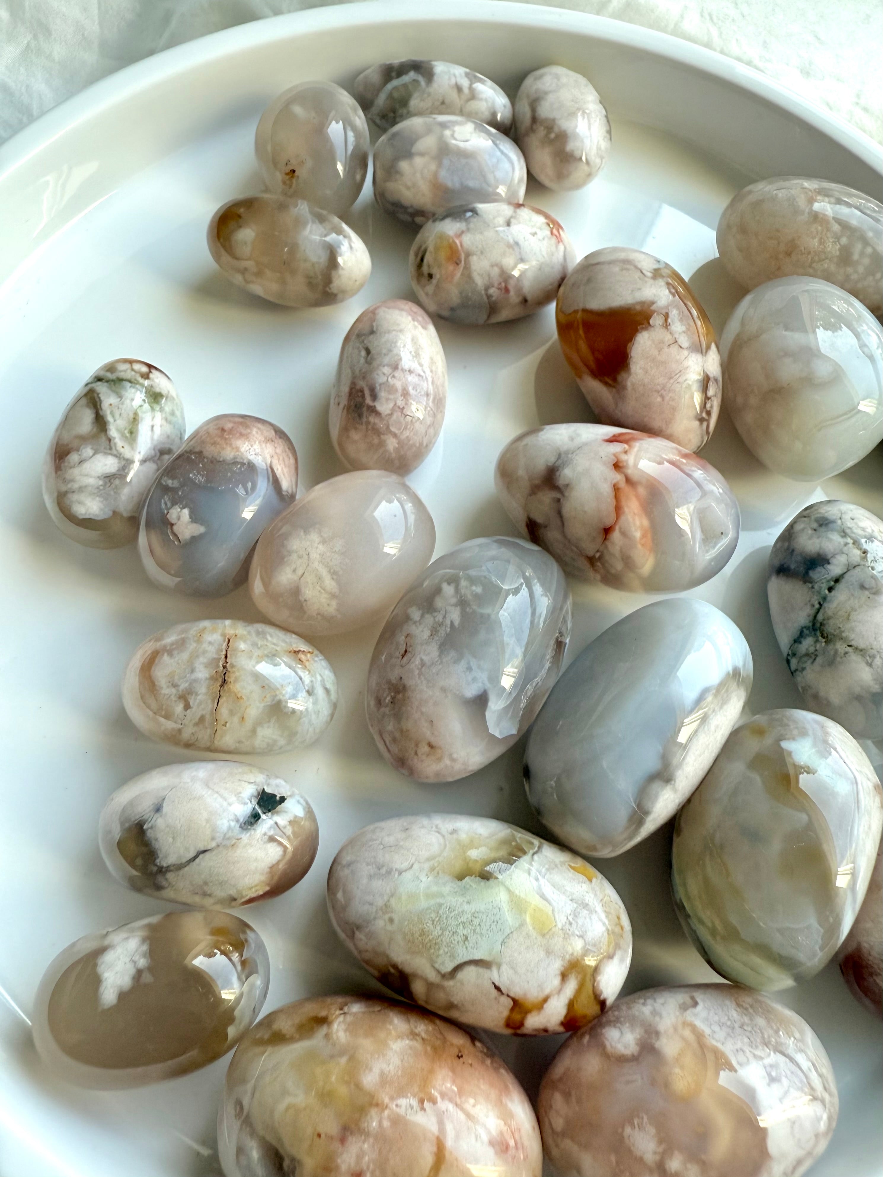 High quality Flower Agate tumbled stones with beautiful pastel colors on a white plate