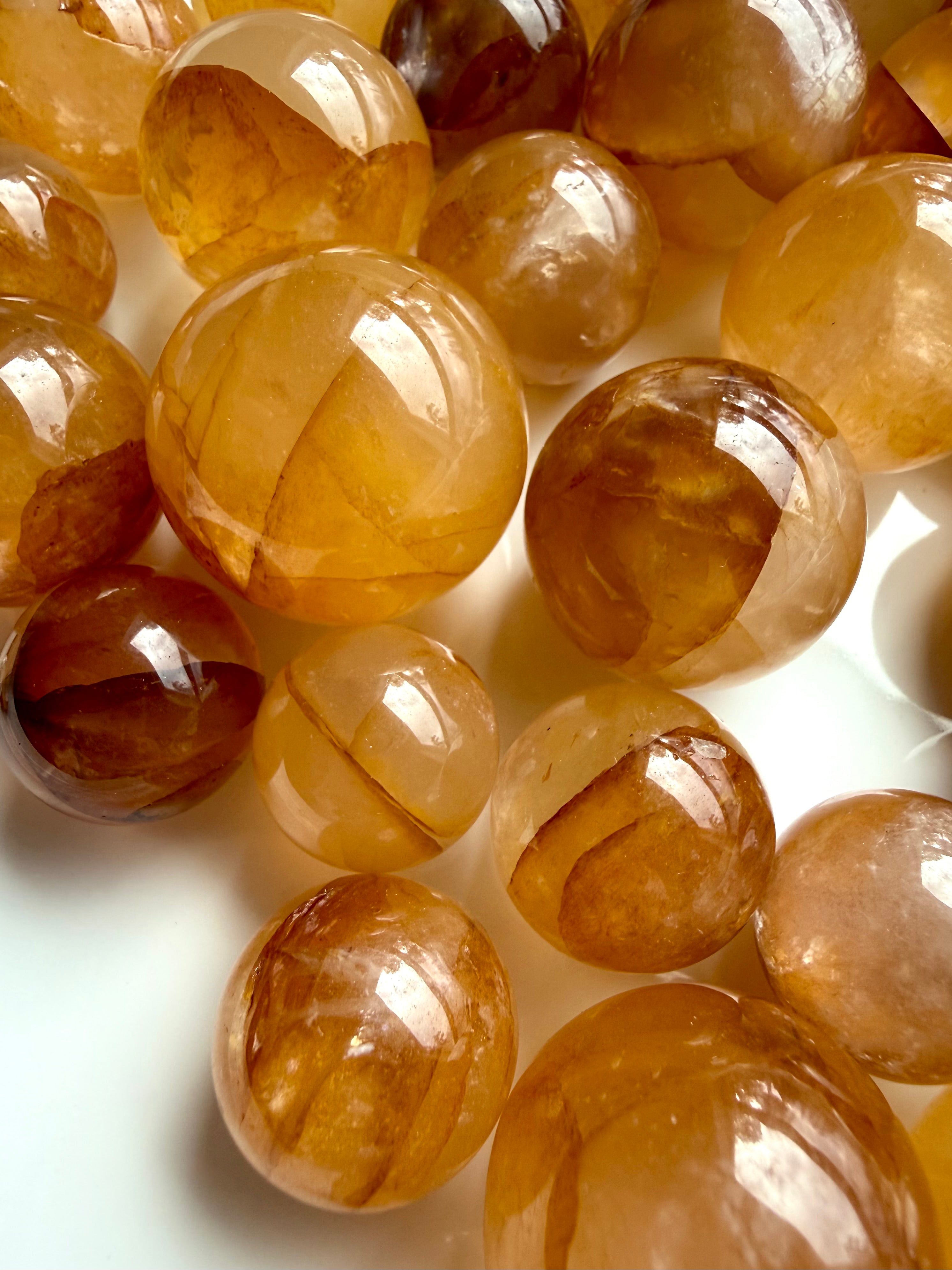 golden healer quartz spheres close up with golden veils and internal mineral formations