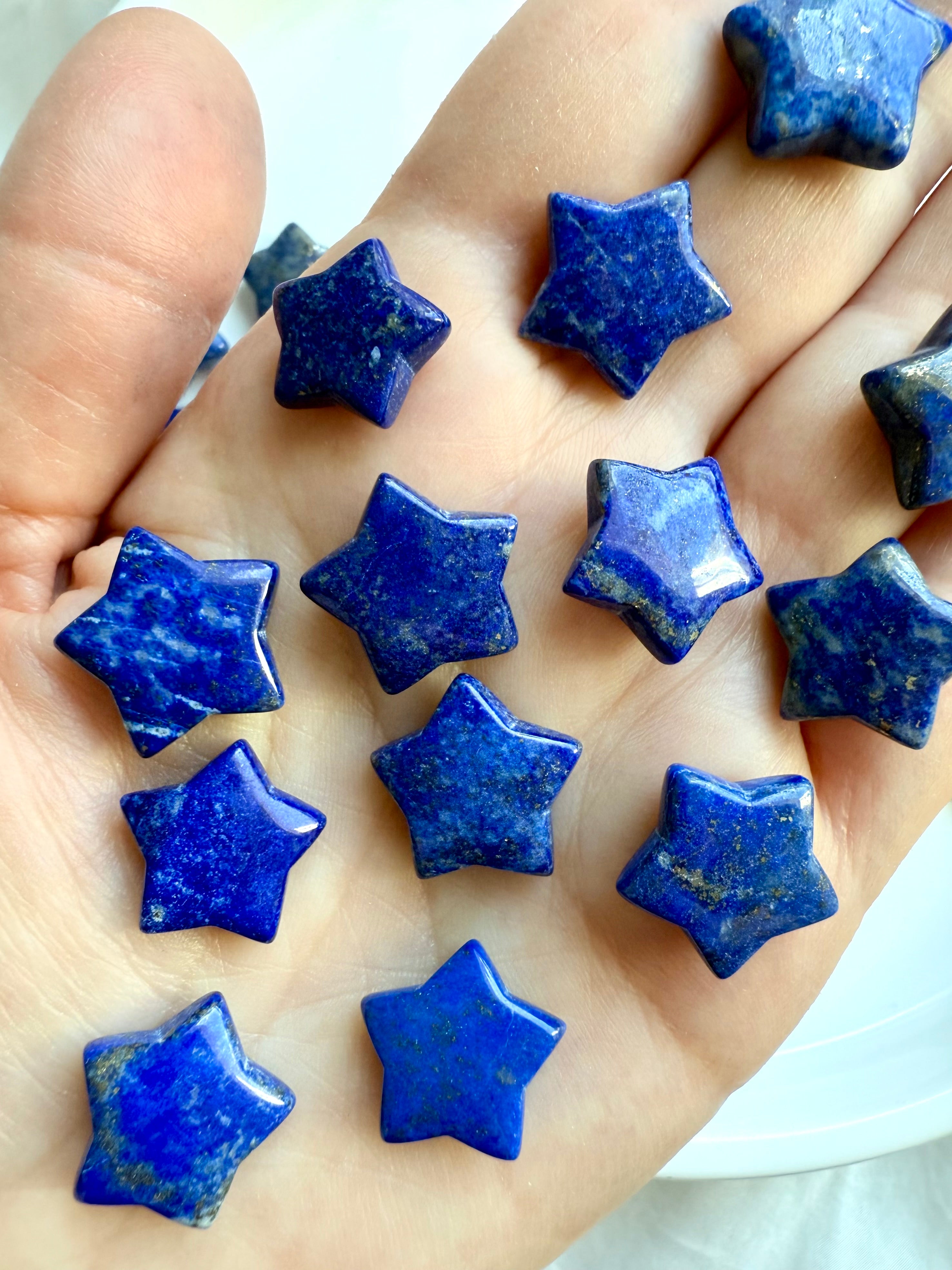 Close-up of Lapis Lazuli star crystal with deep blue color and metallic flecks on a woman's hand