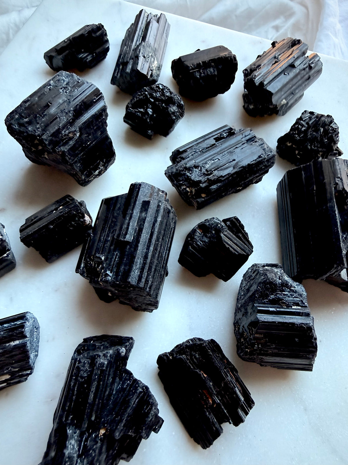 Black Tourmaline grounding crystals in varied raw formations with natural striations and rough surfaces