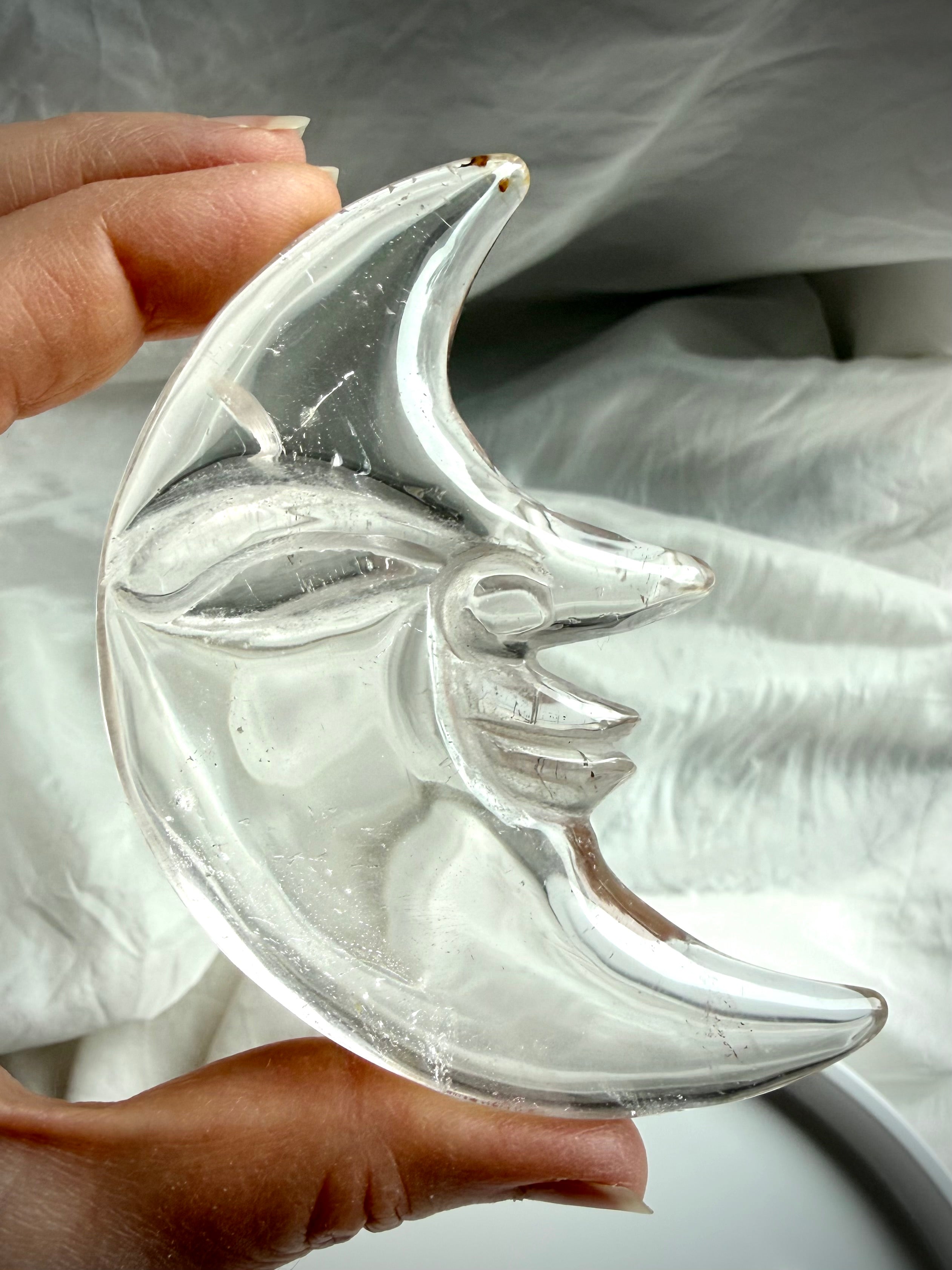Reverse side of Clear Quartz Moon Face carving showing intricate carving, polished finish, and exceptional crystal clarity
