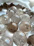 Mini Smoky Quartz spheres displayed in marble bowl with grounding earthy brown and gray tones
