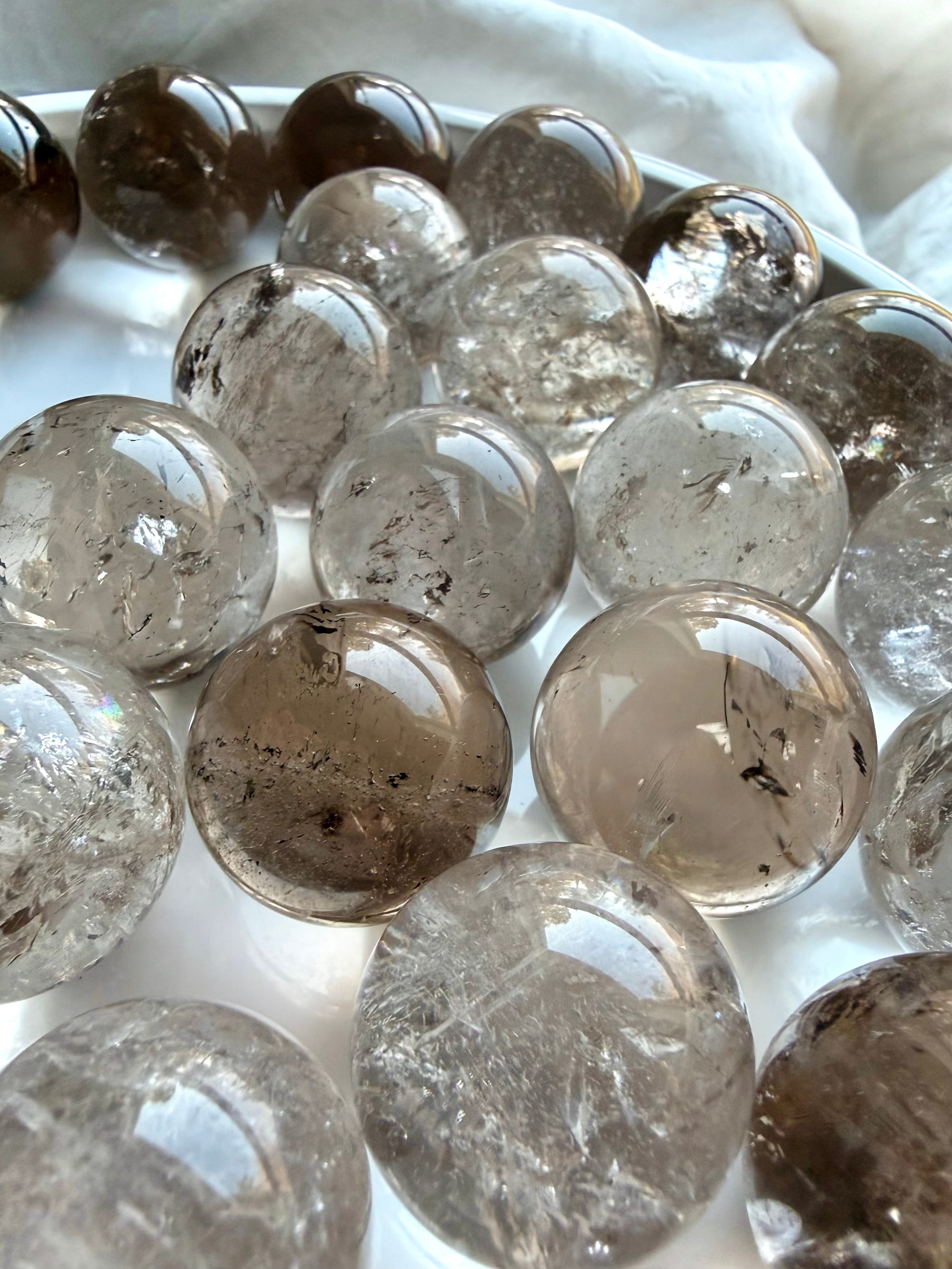 Mini Smoky Quartz spheres displayed in marble bowl with grounding earthy brown and gray tones