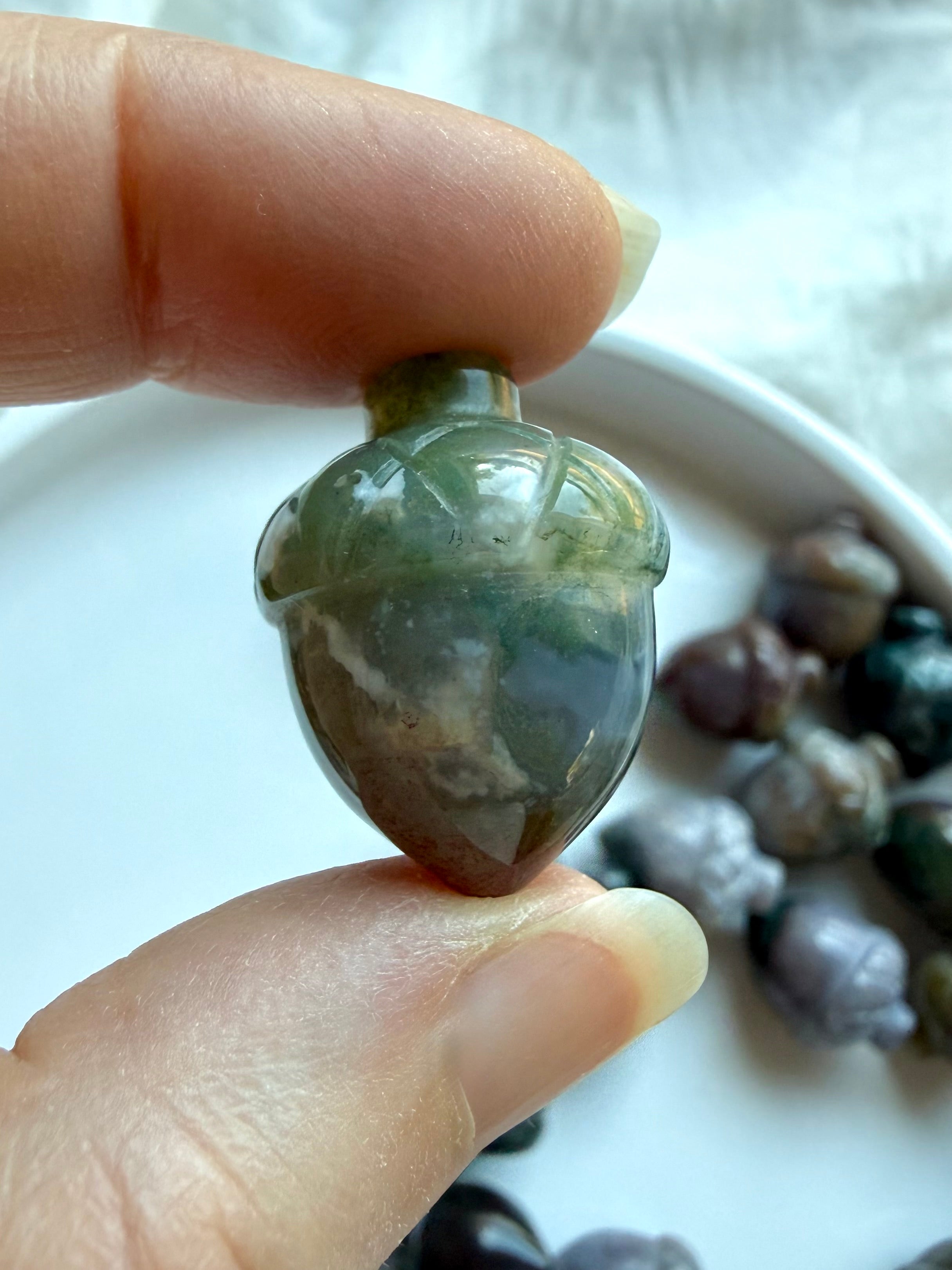 Green and mauve Ocean Jasper acorn held in hand showing detailed natural patterning and smooth glossy polish
