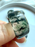 close-up moss agate statement ring worn on finger with scenic dendritic inclusions and polished translucent finish