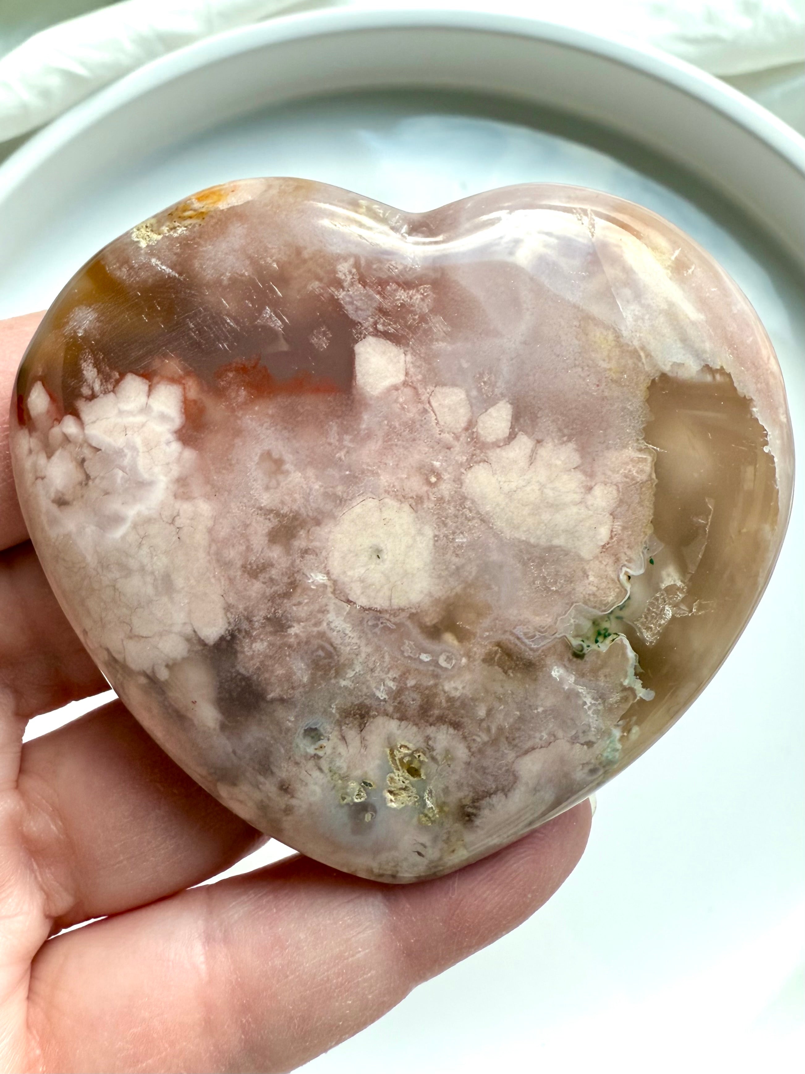 Hand holding the Pink Amethyst and Flower Agate crystal heart with druzy details and earthy hues