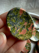 unakite palm stone held in hand for grounding energy compassion and inner balance