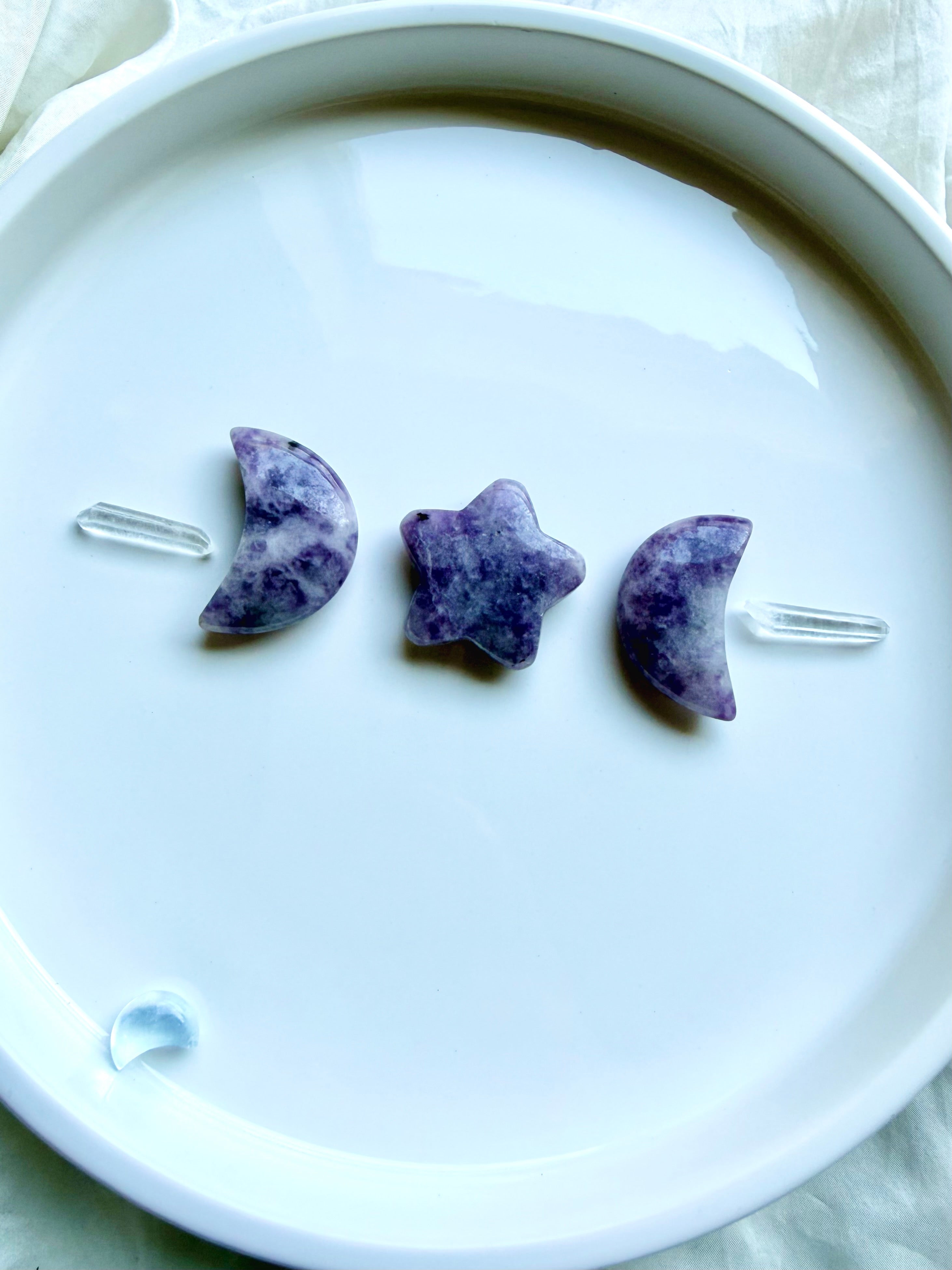 Small Lepidolite crescent moon and star carvings displayed on white surface for meditation, altar decor and crystal gifting