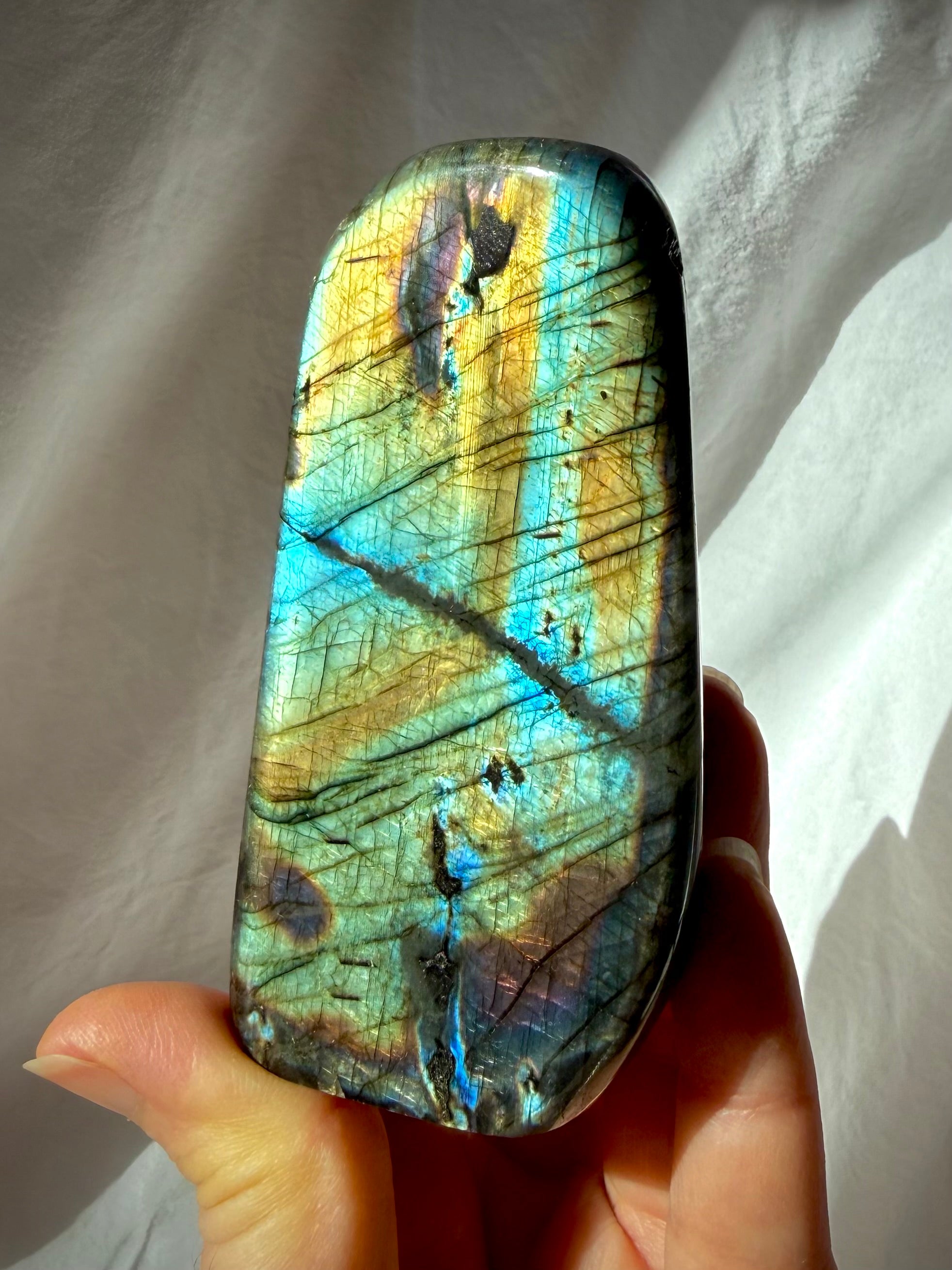 Labradorite crystal freeform with luminous gold, aqua, green, and blue flash across the polished face