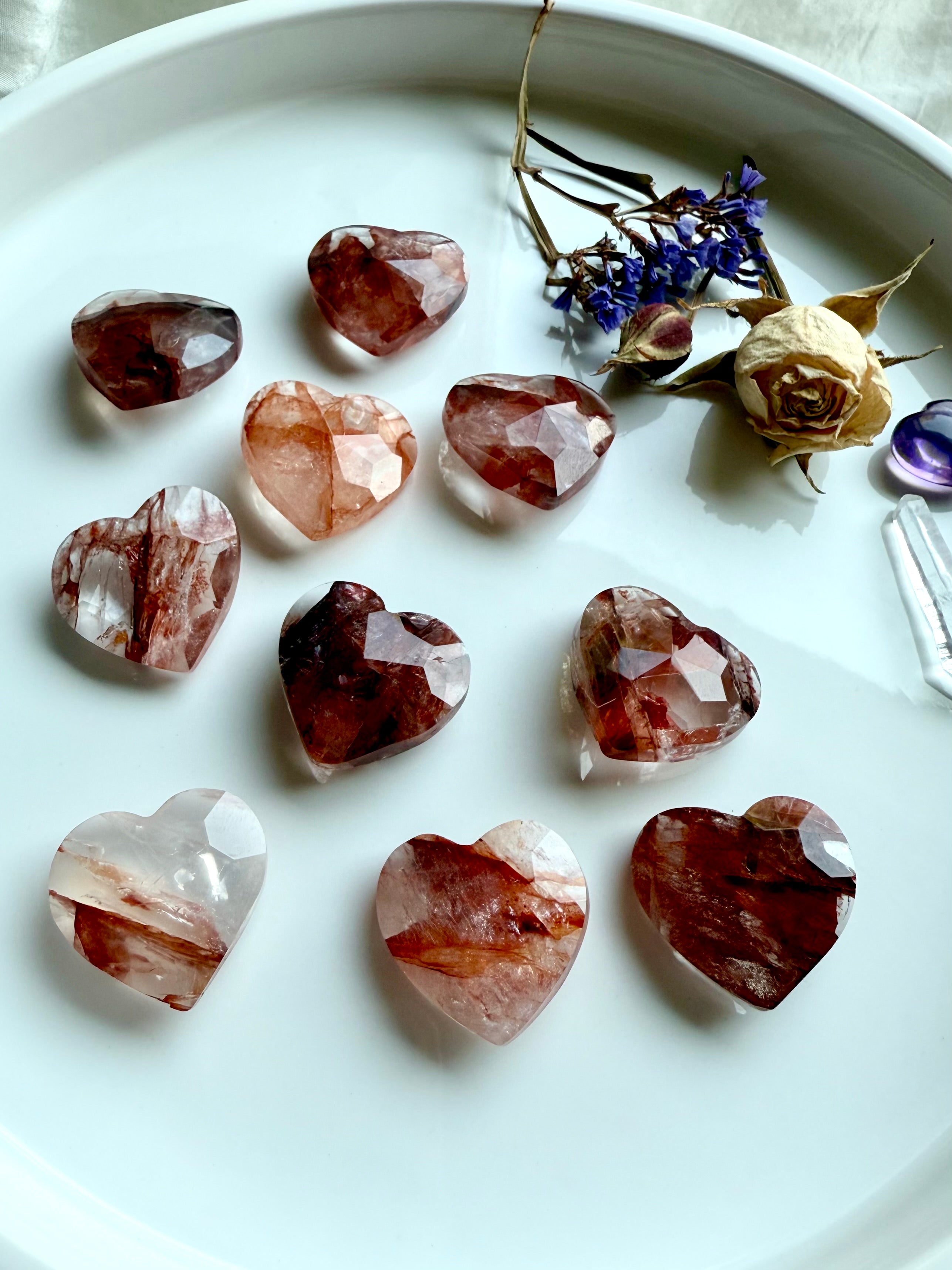 Array of faceted Fire Quartz hearts – natural hematoid quartz carvings showing red hematite inclusions