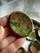 unakite worry stone close up showing natural green epidote and pink feldspar pattern