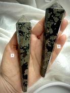 pyrite wand in black matrix options labeled held in hand polished crystal points for selection