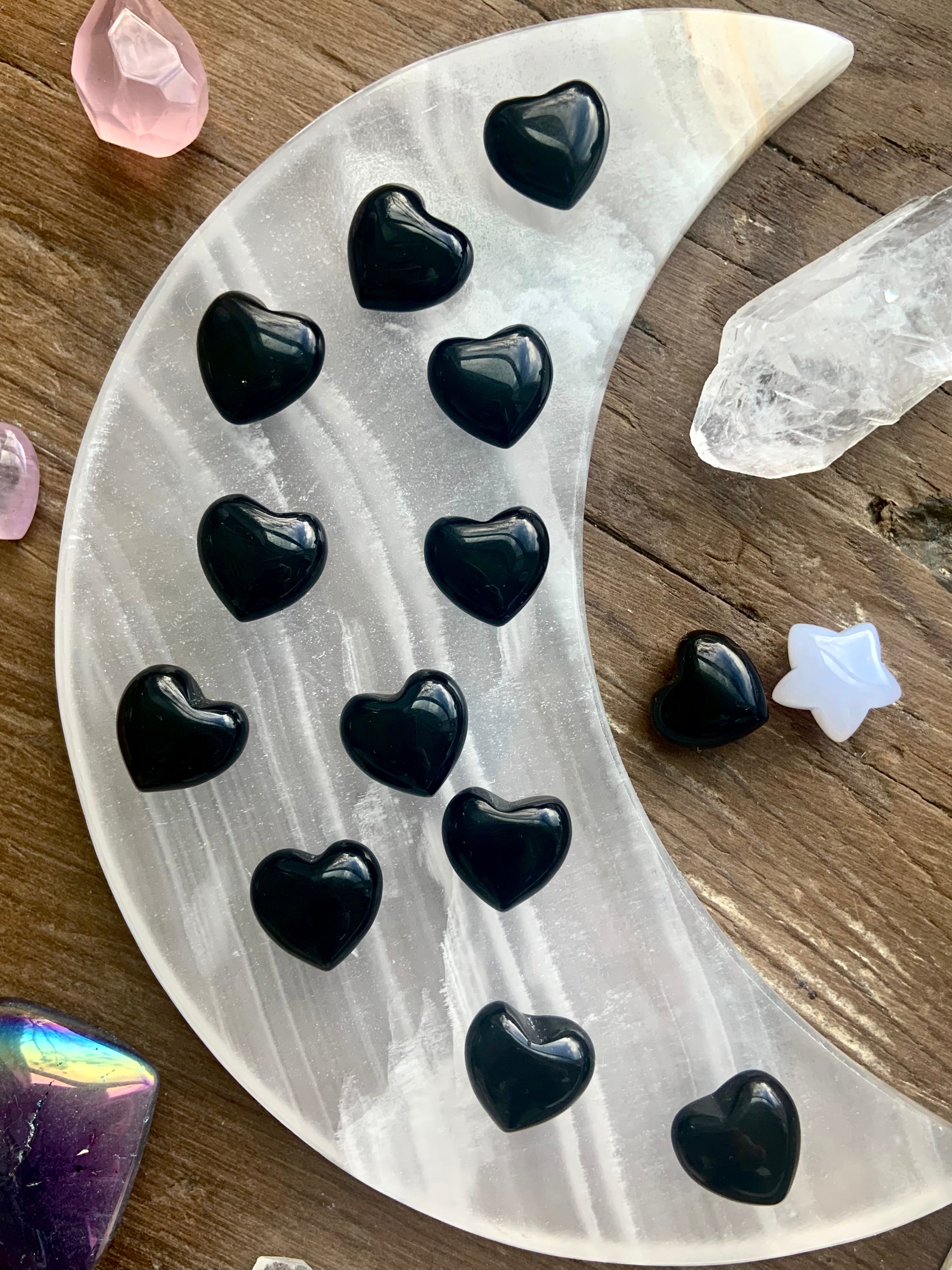 Our mini sized Black Obsidian Hearts photographed on a moon plate with some other crystals