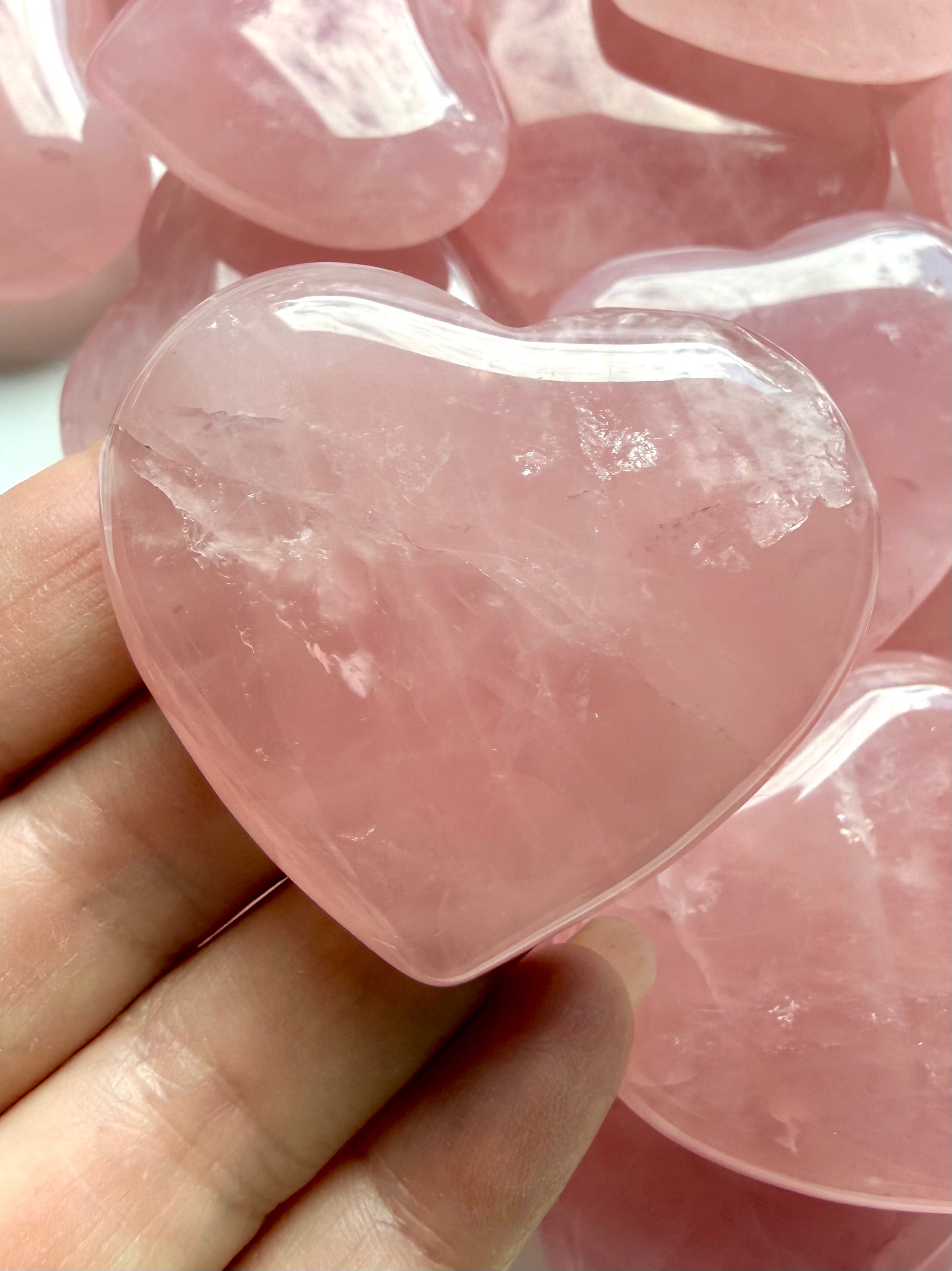 Close-up Rose Quartz heart carving showing translucent pink crystal, natural internal patterns and smooth polished surface
