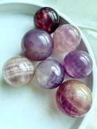polished Silky Magenta Fluorite spheres with lavender, magenta, and cream banding for third eye chakra energy