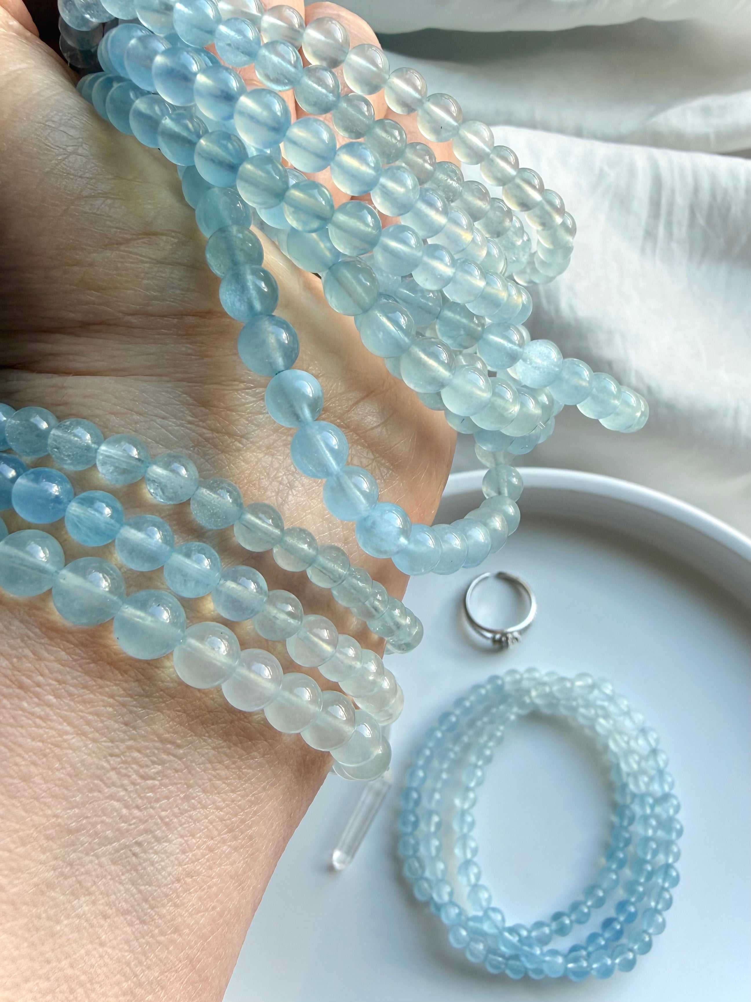 Aquamarine beaded bracelet stack on wrist – March birthstone blue crystal stretch bracelets