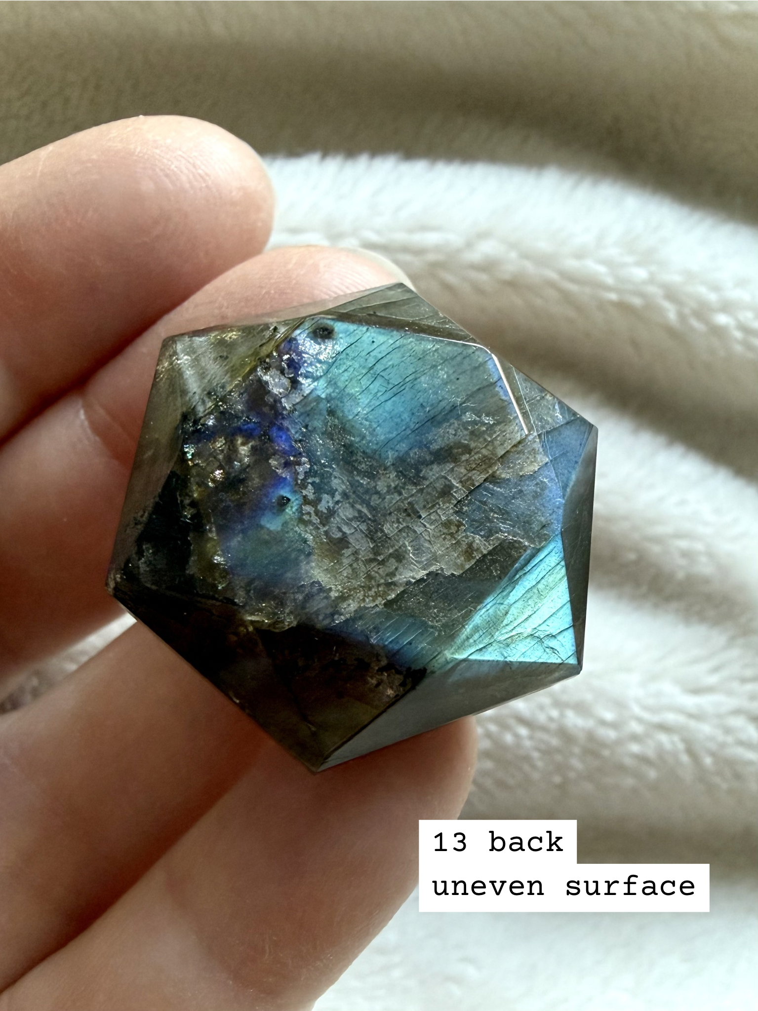 back side of faceted labradorite star of david crystal with glowing blue flash and geometric faceted finish number 13