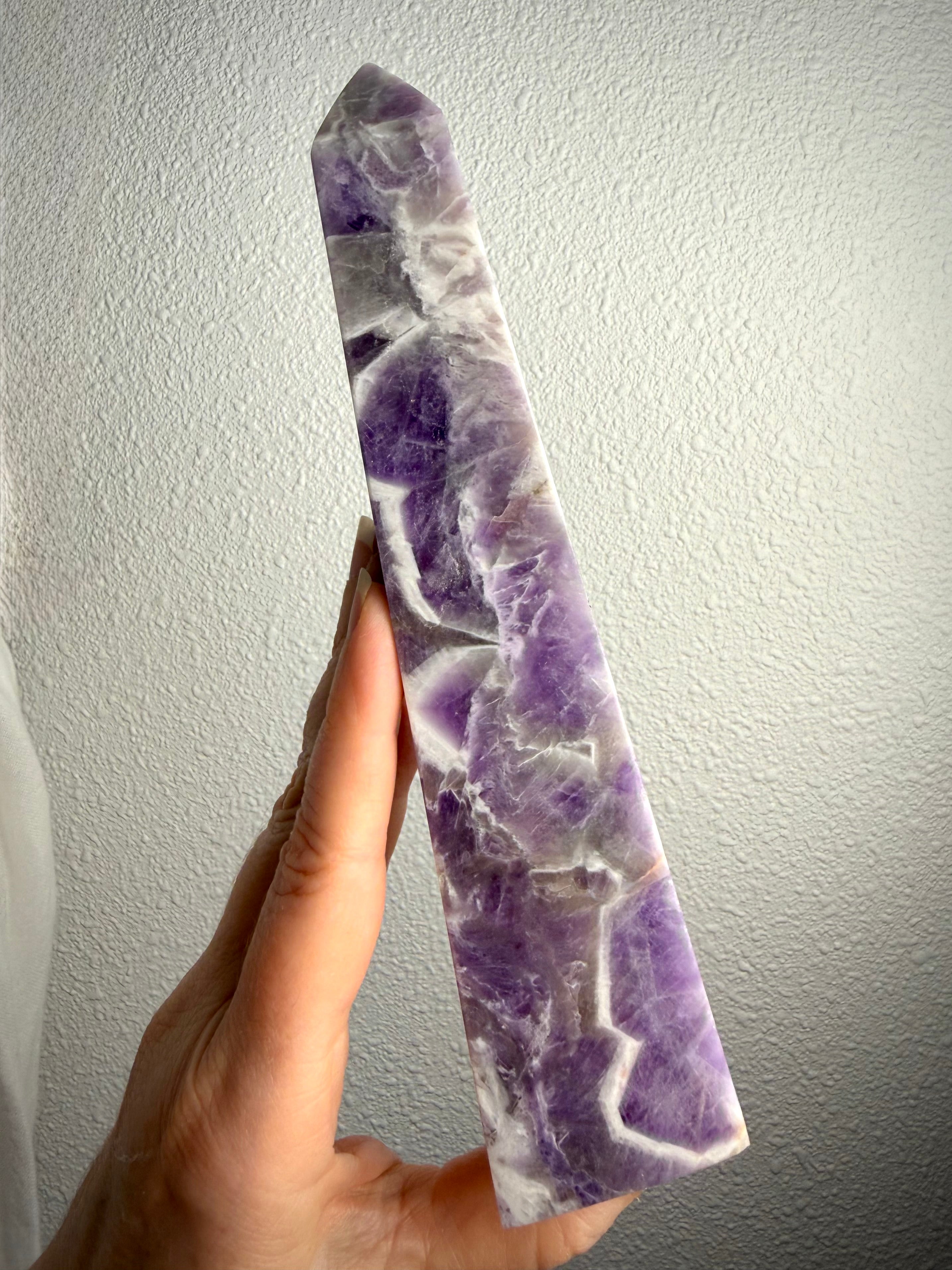 Tall Dream Amethyst crystal point showing its slender shape, rich purple coloring and distinctive zigzag quartz patterns