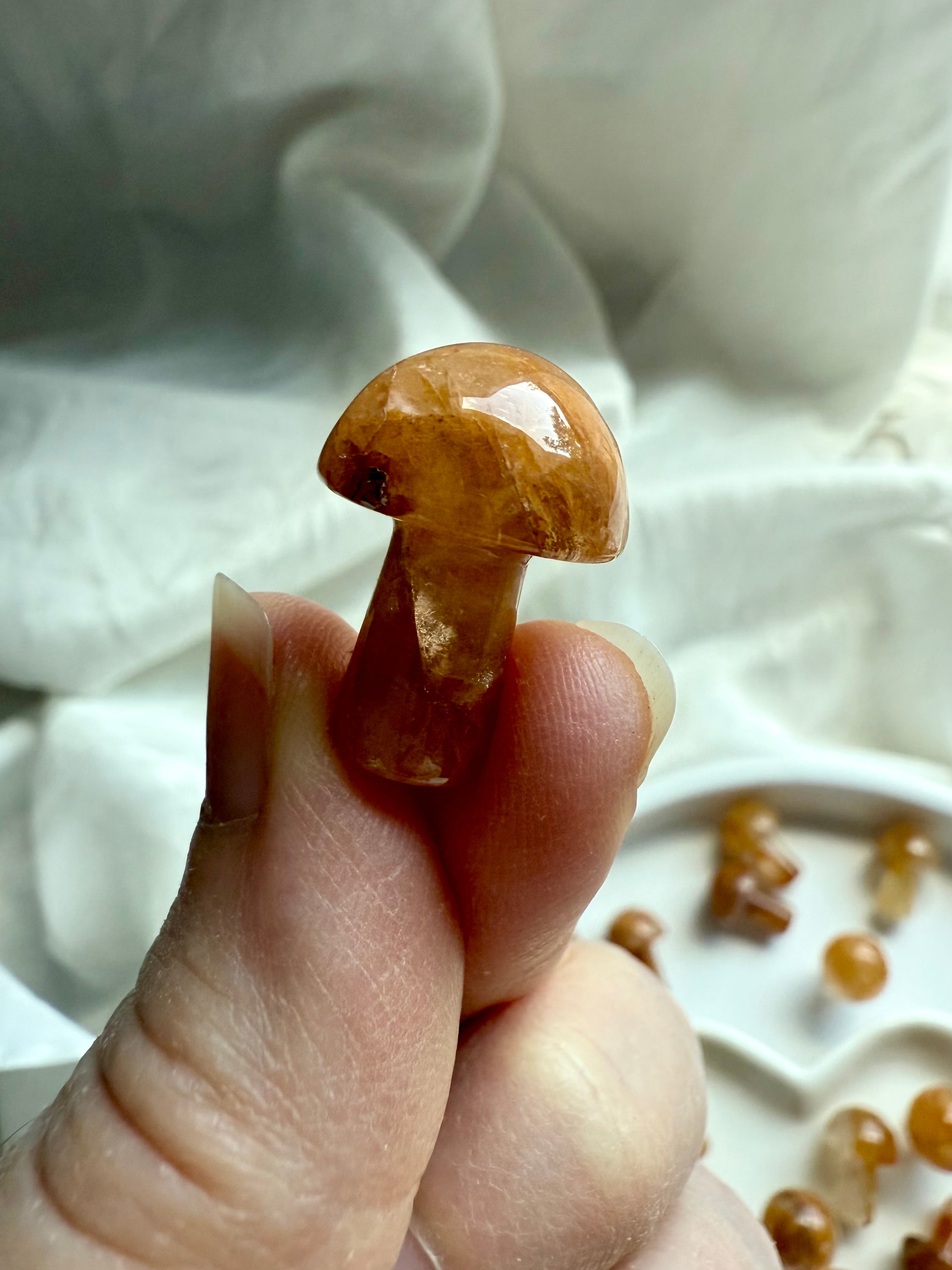 Hand holding polished Golden Healer Quartz mushroom carving — mini crystal talisman for chakra alignment, meditation, and Solar Plexus empowerment.