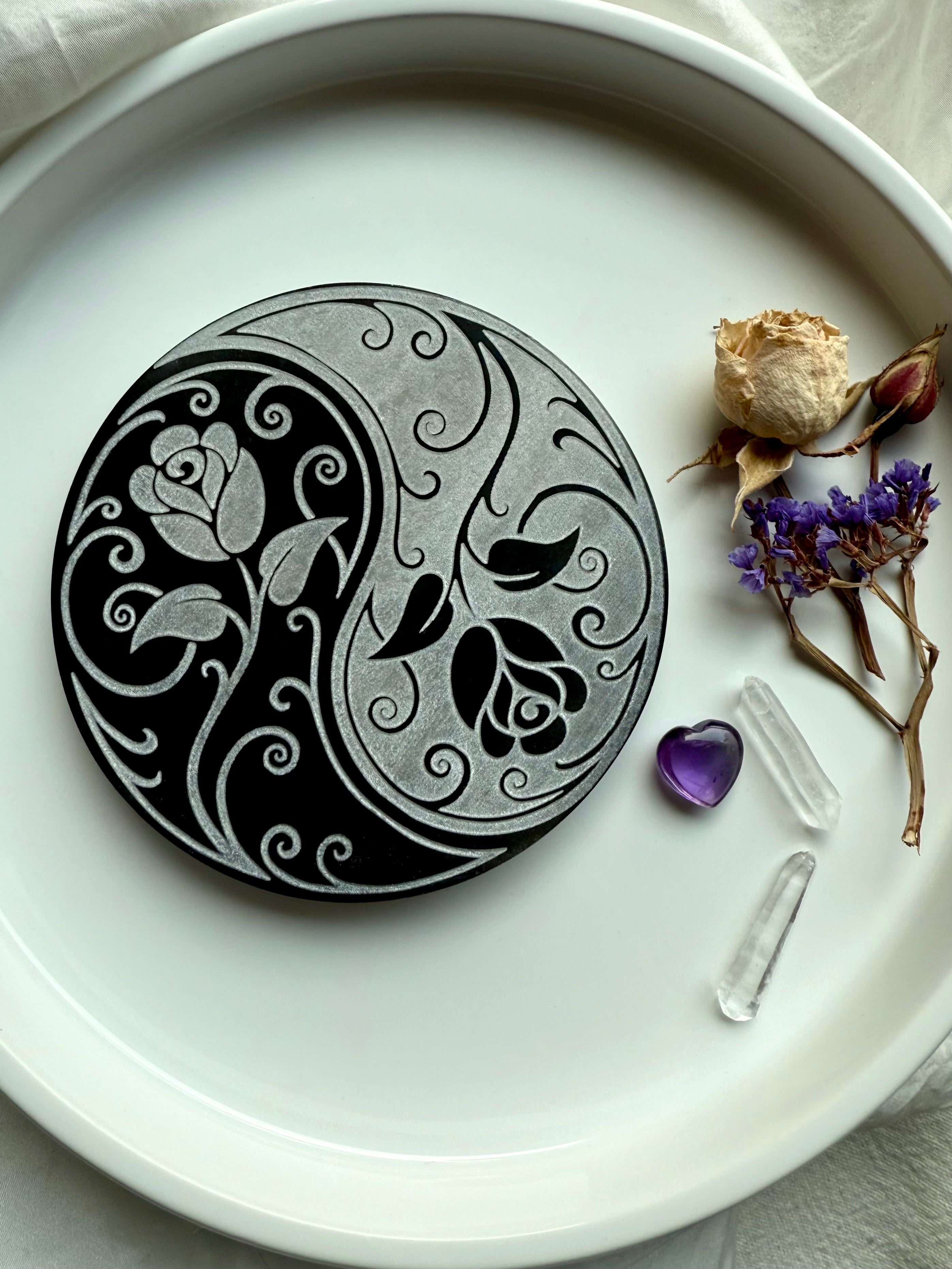 Selenite charging plate with yin yang rose design for energy cleansing, styled with crystals and dried flowers on white background