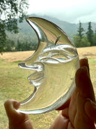 One-of-a-kind Clear Quartz Moon Face carving with a landscape in the background, highlighting remarkable transparency and polished crystal beauty