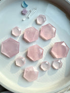 Overhead array of rose quartz hexagon crystals on white background, translucent pink sacred geometry carvings for Heart Chakra healing