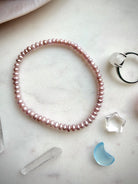 single pink freshwater pearl bracelet styled with crystals, delicate pearl bracelet for heart chakra healing and emotional balance