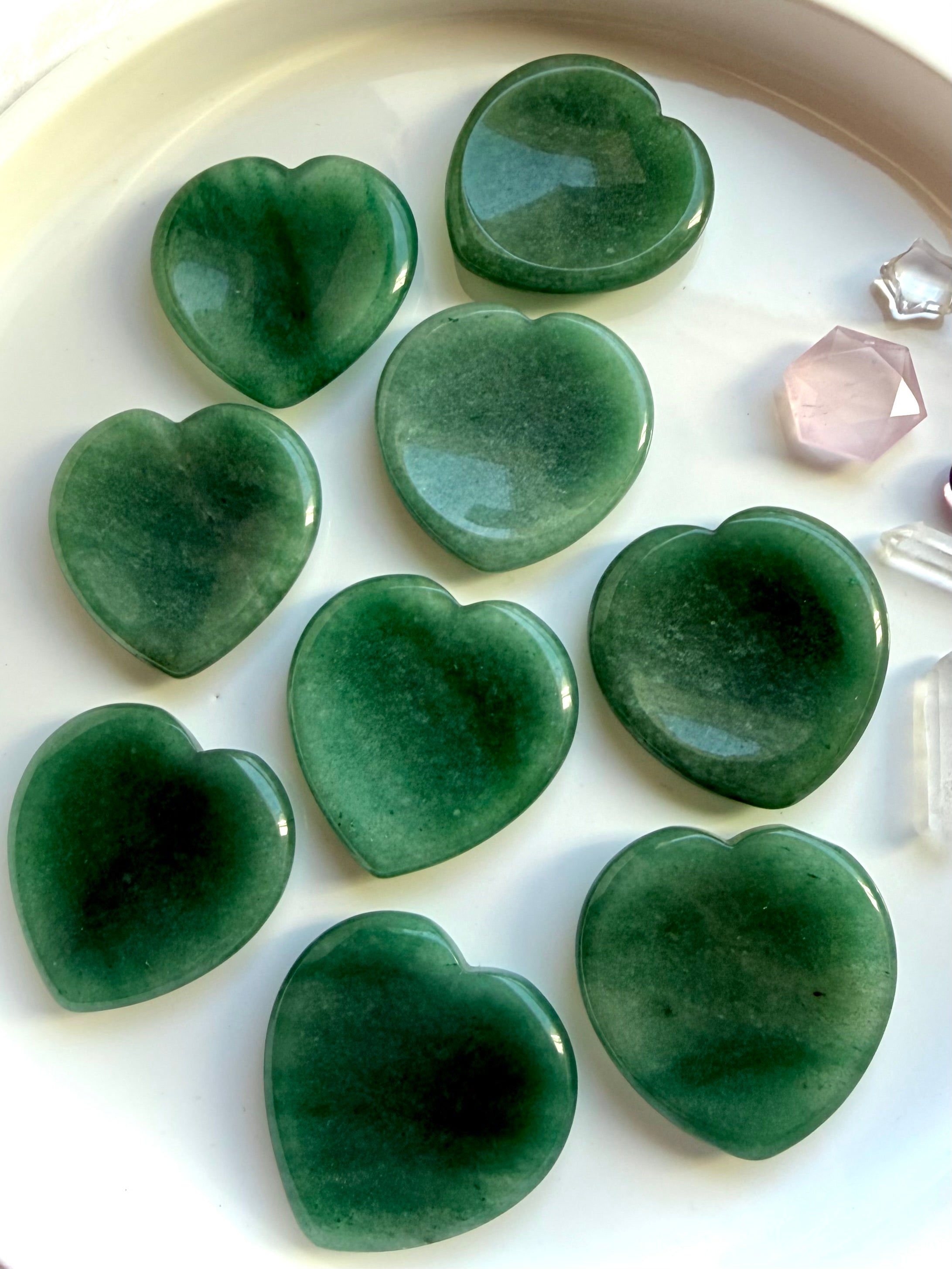 green aventurine heart worry stones arranged on white tray, crystal hearts for abundance, confidence and emotional balance