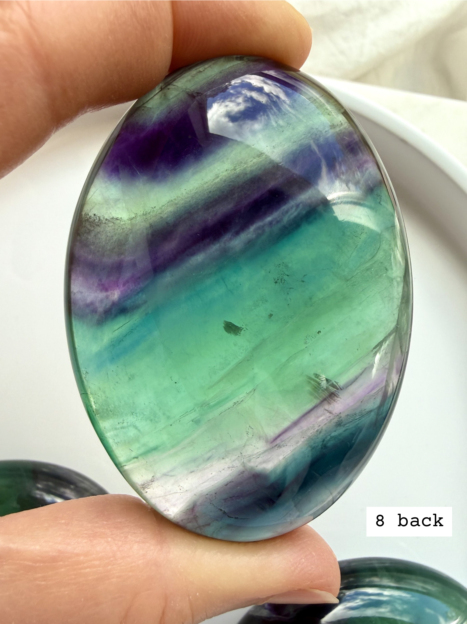 Teal fluorite palm stone #8 back view with rich blue green layers and glowing translucency