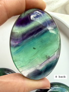Teal fluorite palm stone #8 back view with rich blue green layers and glowing translucency