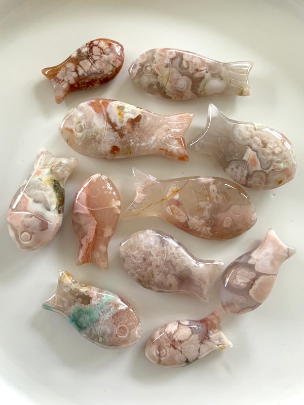 Flower Agate Fish carvings in a variety of sizes, hand carved crystal fish shown on a white plate