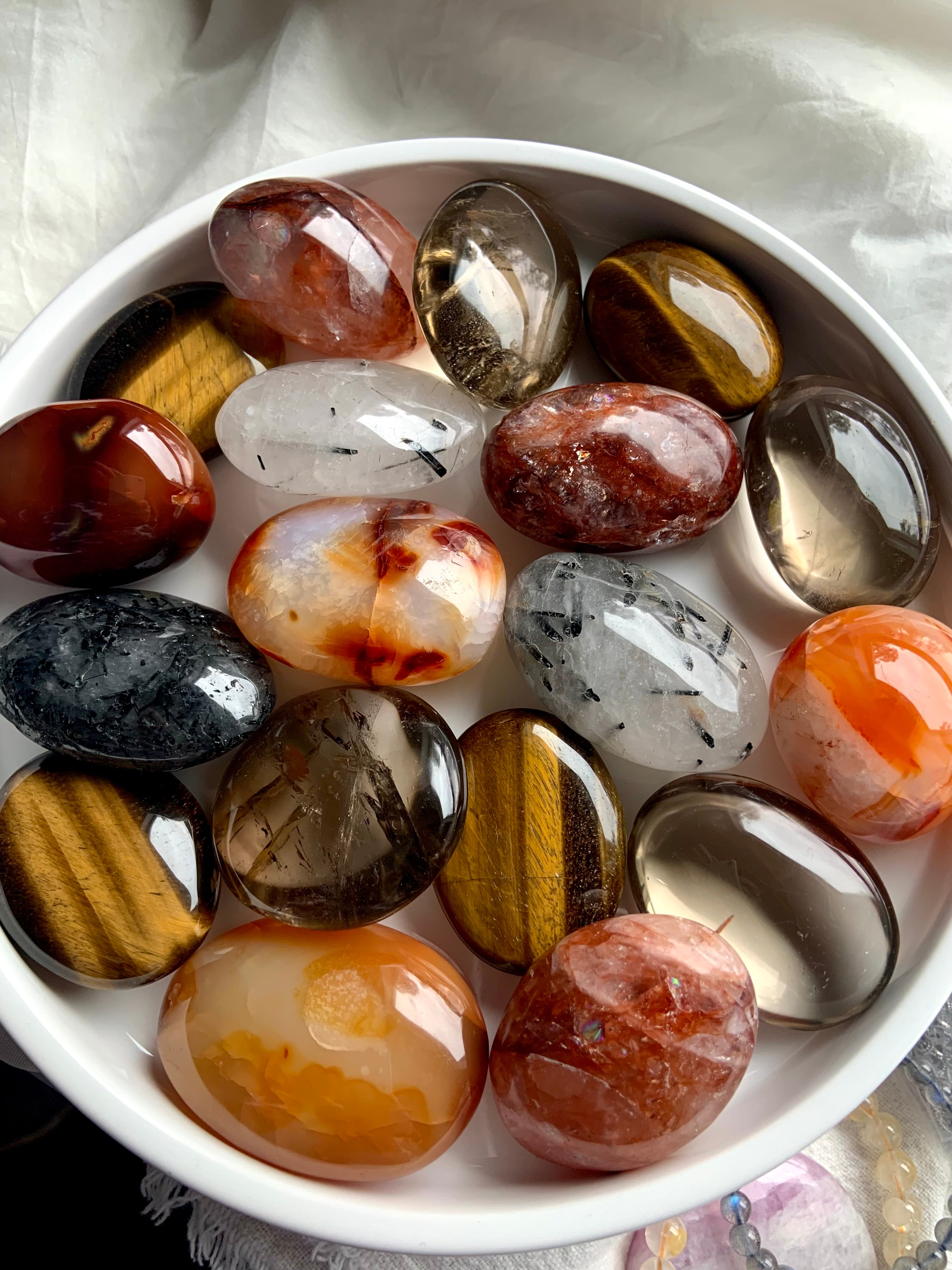 Assorted chakra palm stones in warm, earthy tones — grounding crystals for Root, Sacral &amp; Solar Plexus chakra alignment and energy healing.