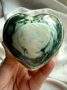 One of a kind Ocean Jasper crystal heart with deep green swirls and cream tones held in hand — polished healing stone for love, balance, and emotional support.