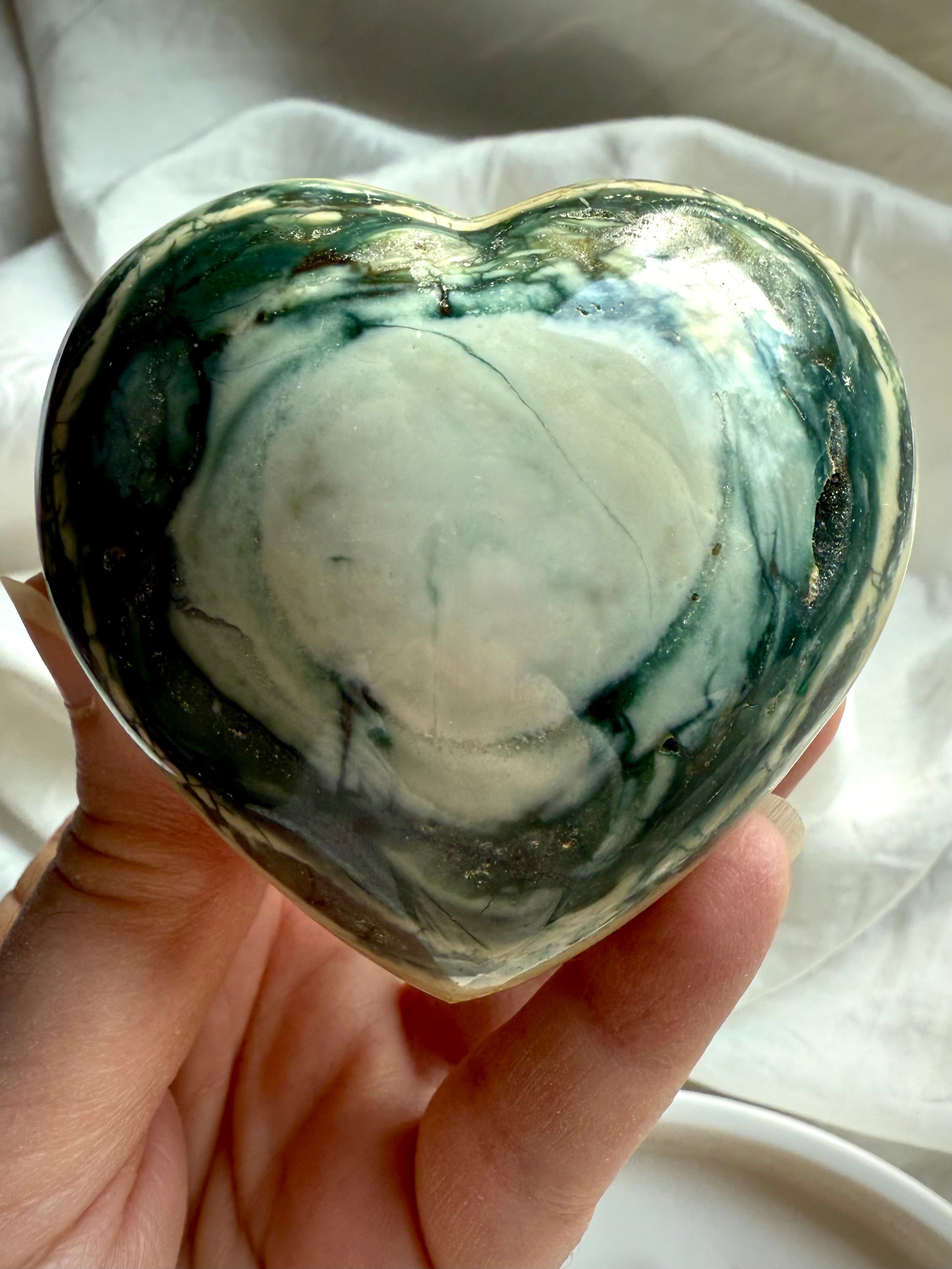 One of a kind Ocean Jasper crystal heart with deep green swirls and cream tones held in hand — polished healing stone for love, balance, and emotional support.