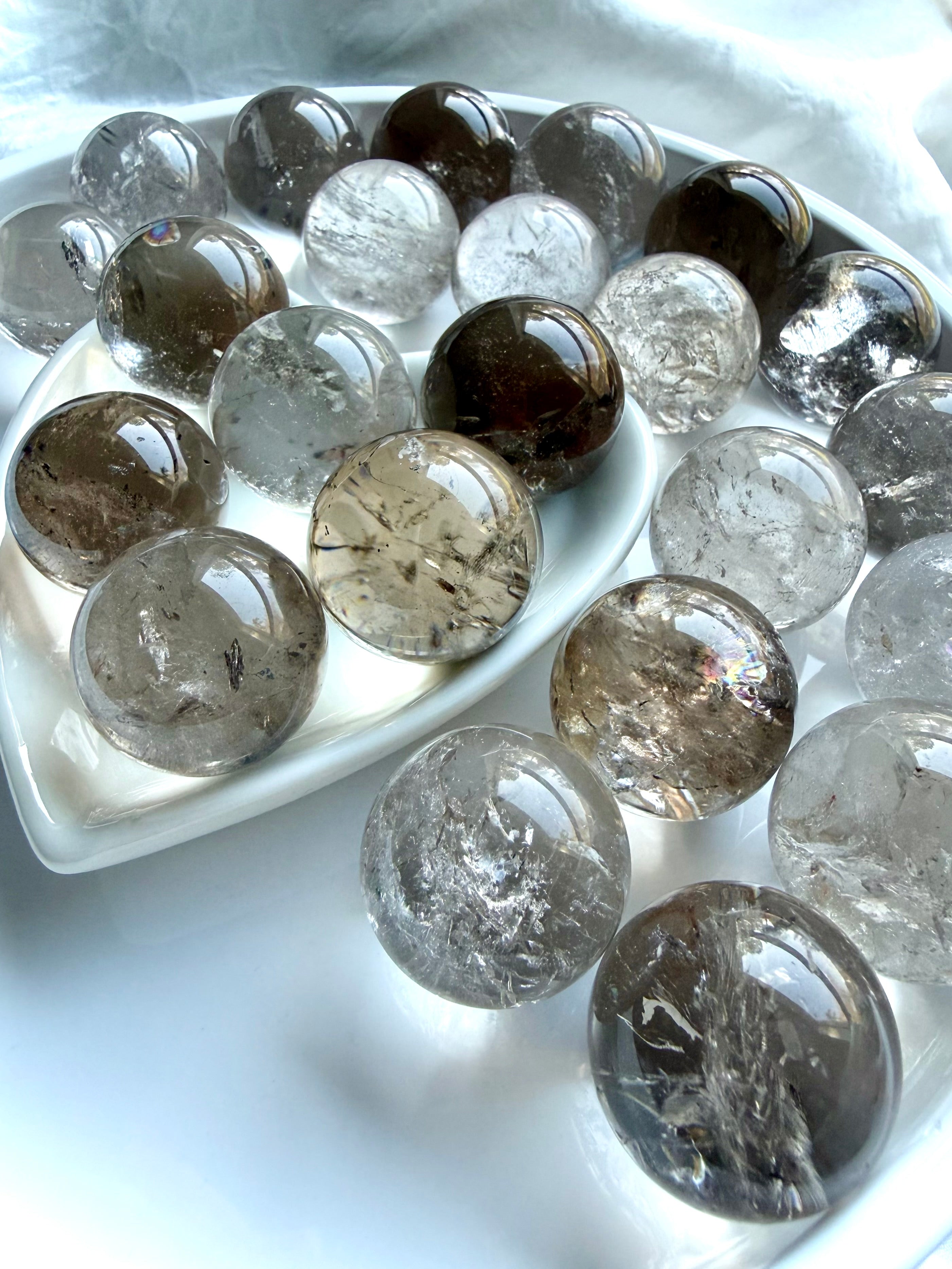 Polished Smoky Quartz crystal spheres with natural inclusions and luminous glassy appearance