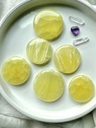 Assortment of lemon calcite crystal discs with amethyst and clear quartz accents