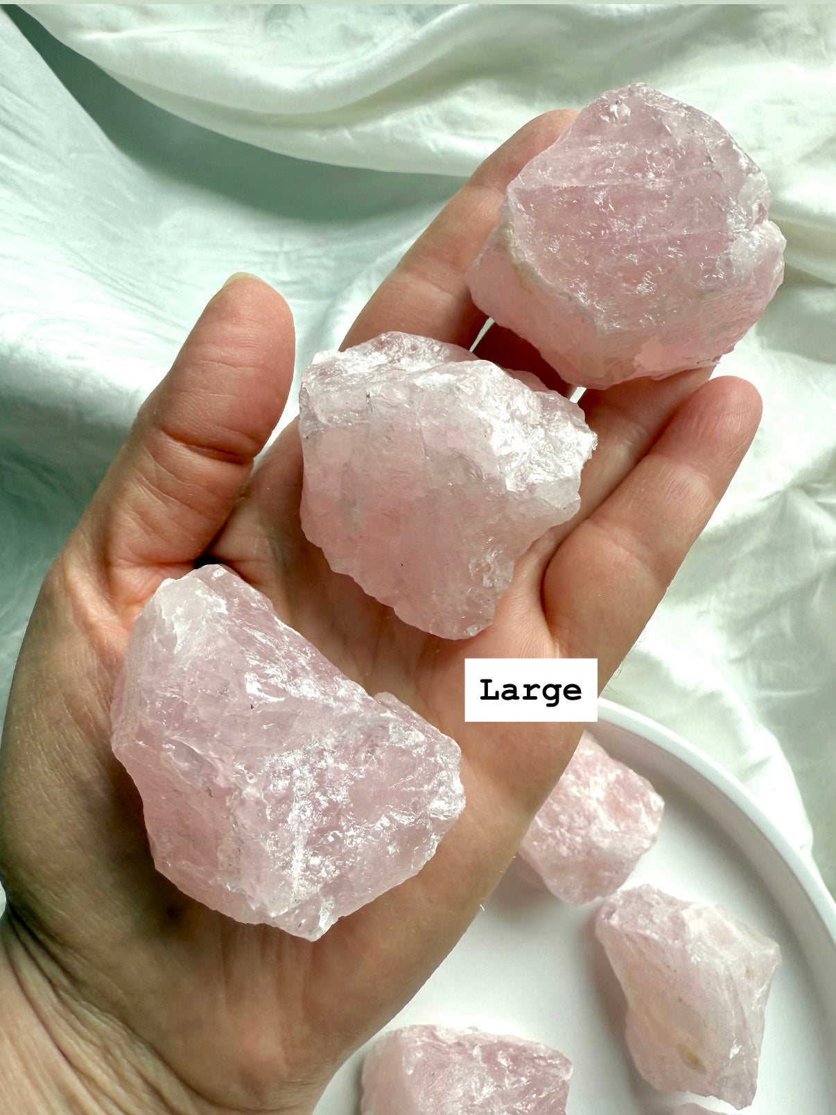Hand holding three large raw Rose Quartz crystal chunks from Madagascar, Heart Chakra healing stones for love and protection