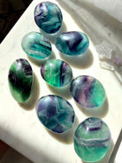 Choose Your Own Rainbow Fluorite Palm Stones with numbered selection and natural ribbon banding