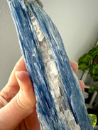 Close-up of blue kyanite crystal with shimmering muscovite + quartz, raw healing stone for throat chakra activation + aura cleansing