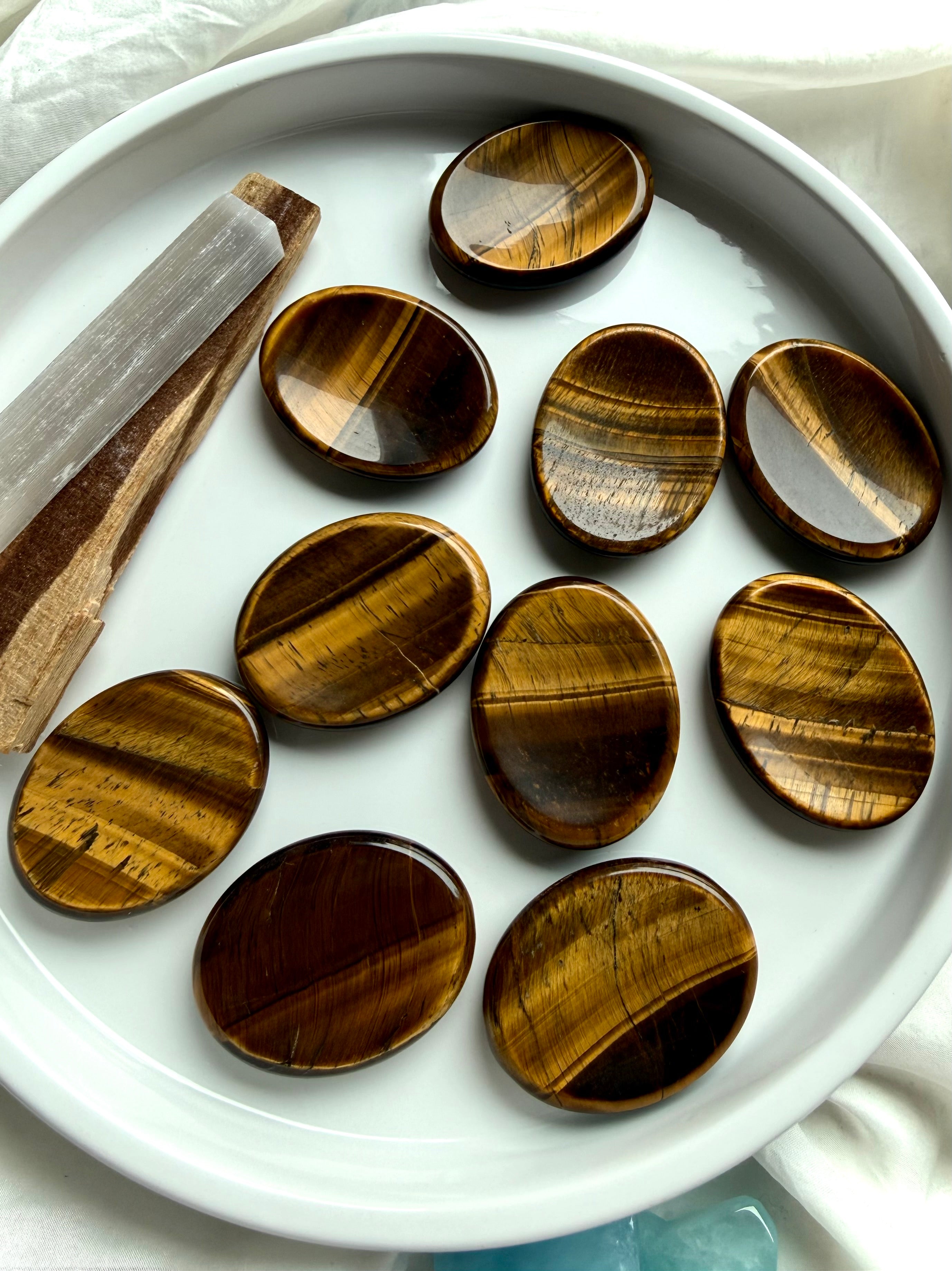 tiger’s eye oval worry stones arranged in ceramic dish, polished thumb stones for protection focus and personal power