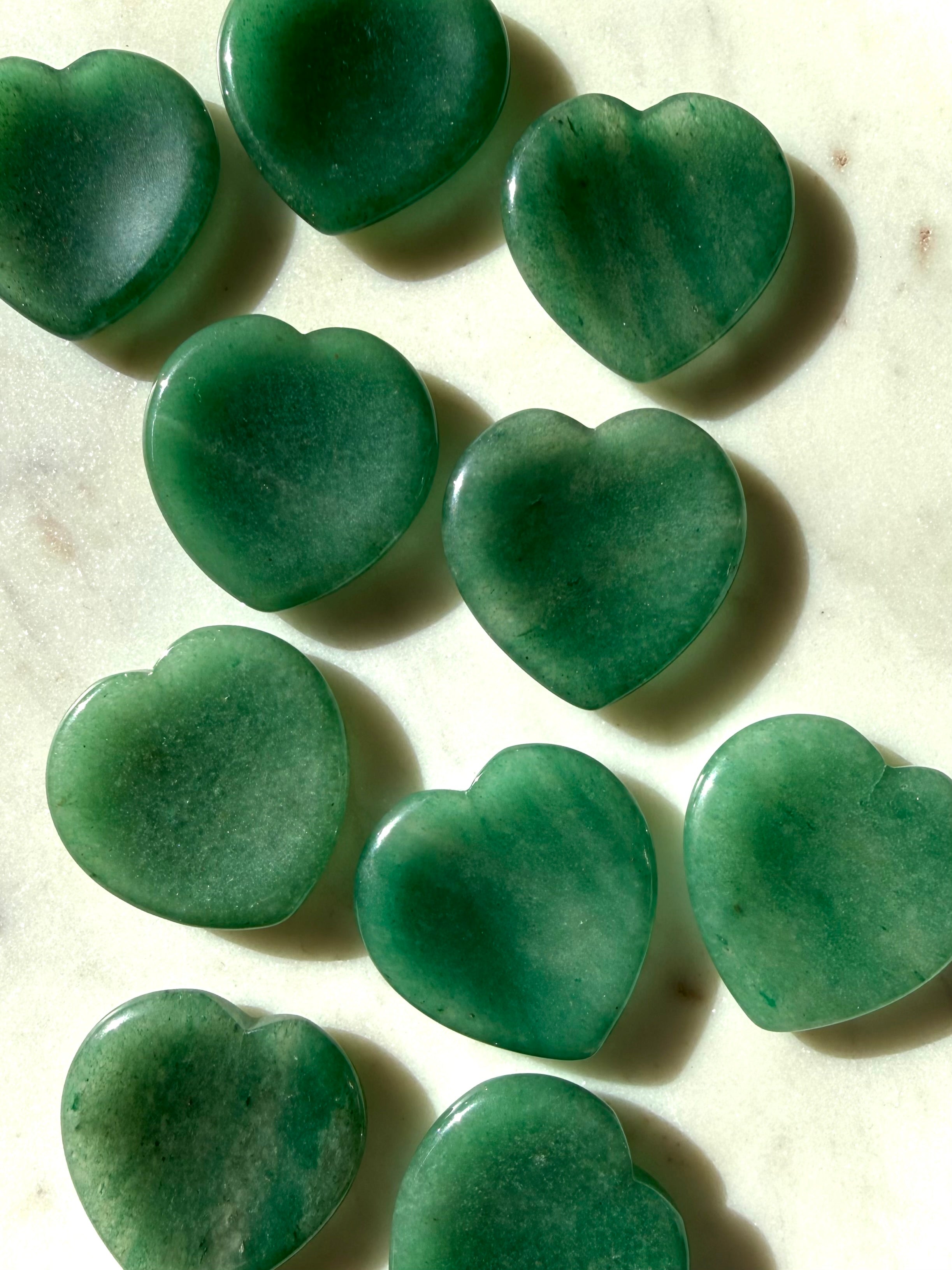 collection of polished green aventurine heart stones displaying natural color variation and organic patterns